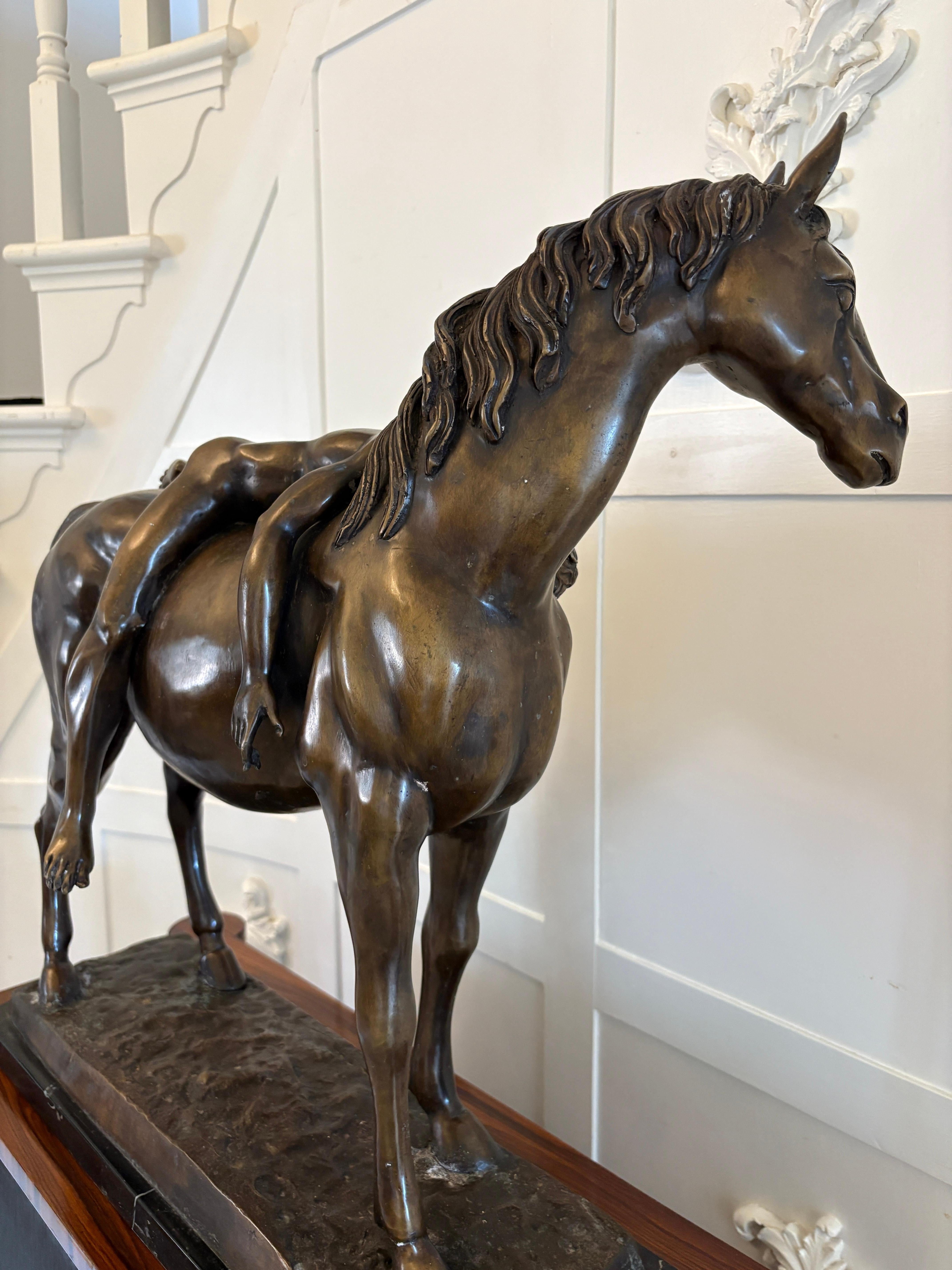 Large antique bronze study of a nude male on horseback having an unconscious man draped across the horse's back, the naturalistic bronze base raised on a marble plinth base, signed to the bronze base.

An exceptional piece depicting a fabulous