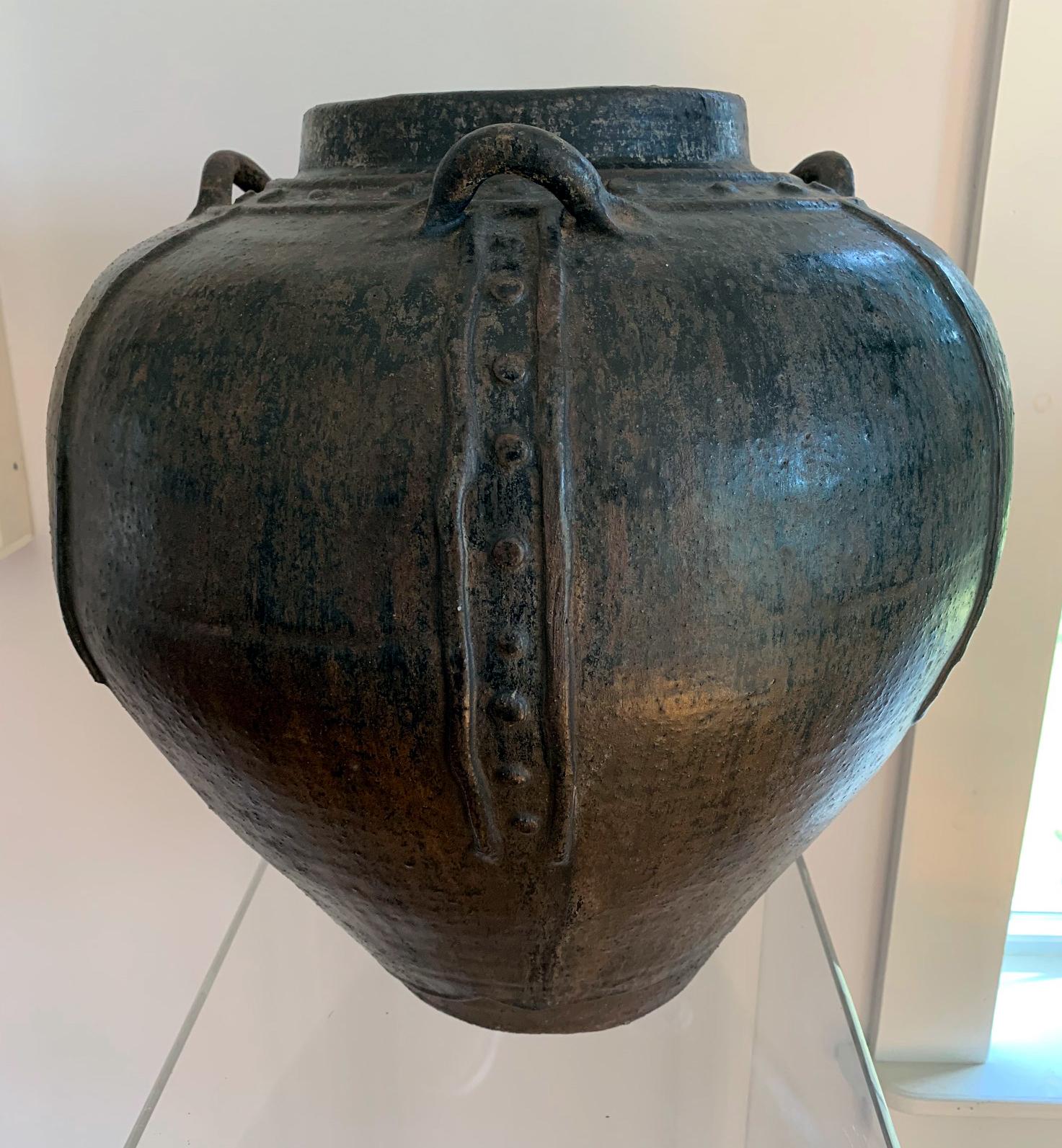 A large ceramic storage jar with dark brown black glaze from Martaban Area of Burma (nowadays Myanmar) circa 15th-16th century. Martaban jar is a generic term for large heavy stoneware jars that were shipped out of the port of Martaban. It doesn't