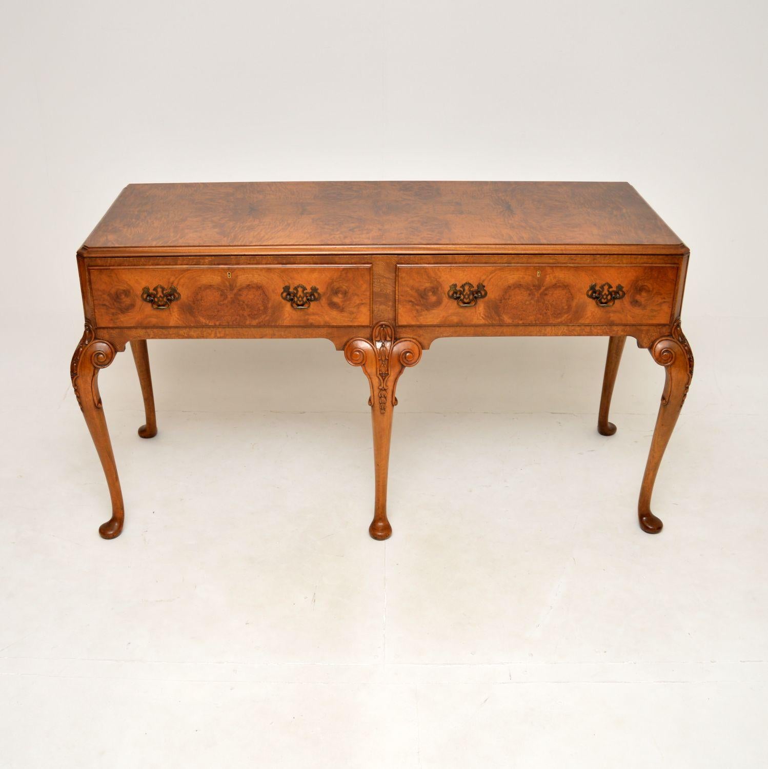 A stunning and large antique burr walnut console table. This is in the Queen Anne style, it was made in England and dates from around the 1900-1910 period.

It is of superb quality, with beautiful crisp carving on the legs and gorgeous burr walnut