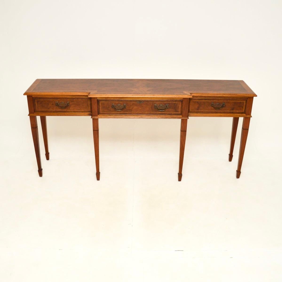 Un'imponente e grande consolle antica in radica di noce. È in stile georgiano, è stato realizzato in Inghilterra e risale agli anni '1950 circa.

È di qualità eccezionale e di grandi dimensioni, con un design a spacco. Il noce ha una splendida