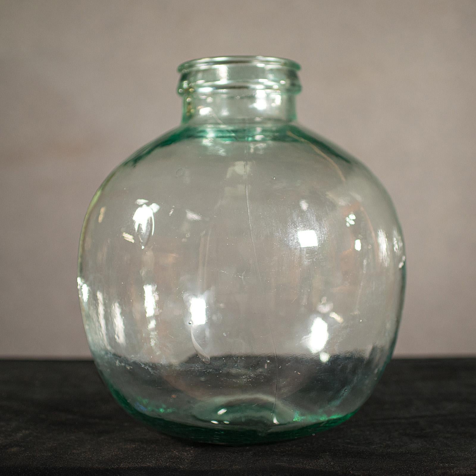 This is a large antique carboy. An English, glass storage jar or terrarium, dating to the late Victorian period, circa 1900.

Generously sized with charming antique glass and pleasing colour
Displays a desirable aged patina with some visible blowing