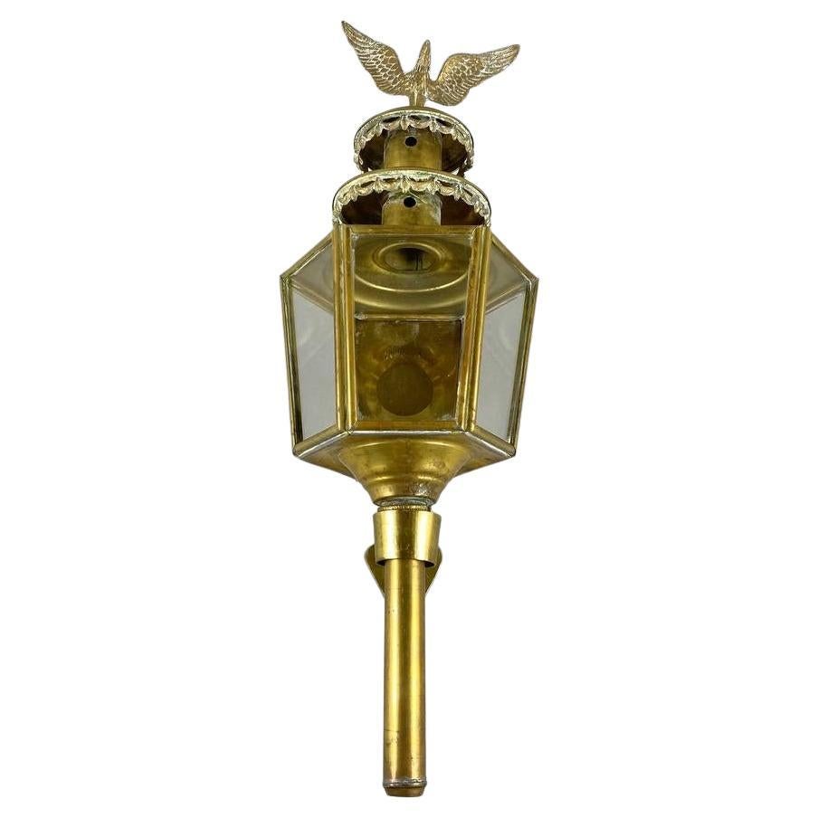 Antique brass carriage lamp, made in Belgium, circa 1920. 

The huge carriage lamp is adorned with decorative crowns and an imposing eagle at the top. Original glass surrounds the lamp on five sides.

Carriage lights were used to illuminate the