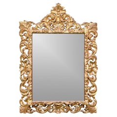 Grand miroir baroque sculpté, enduit de gesso et fortement doré