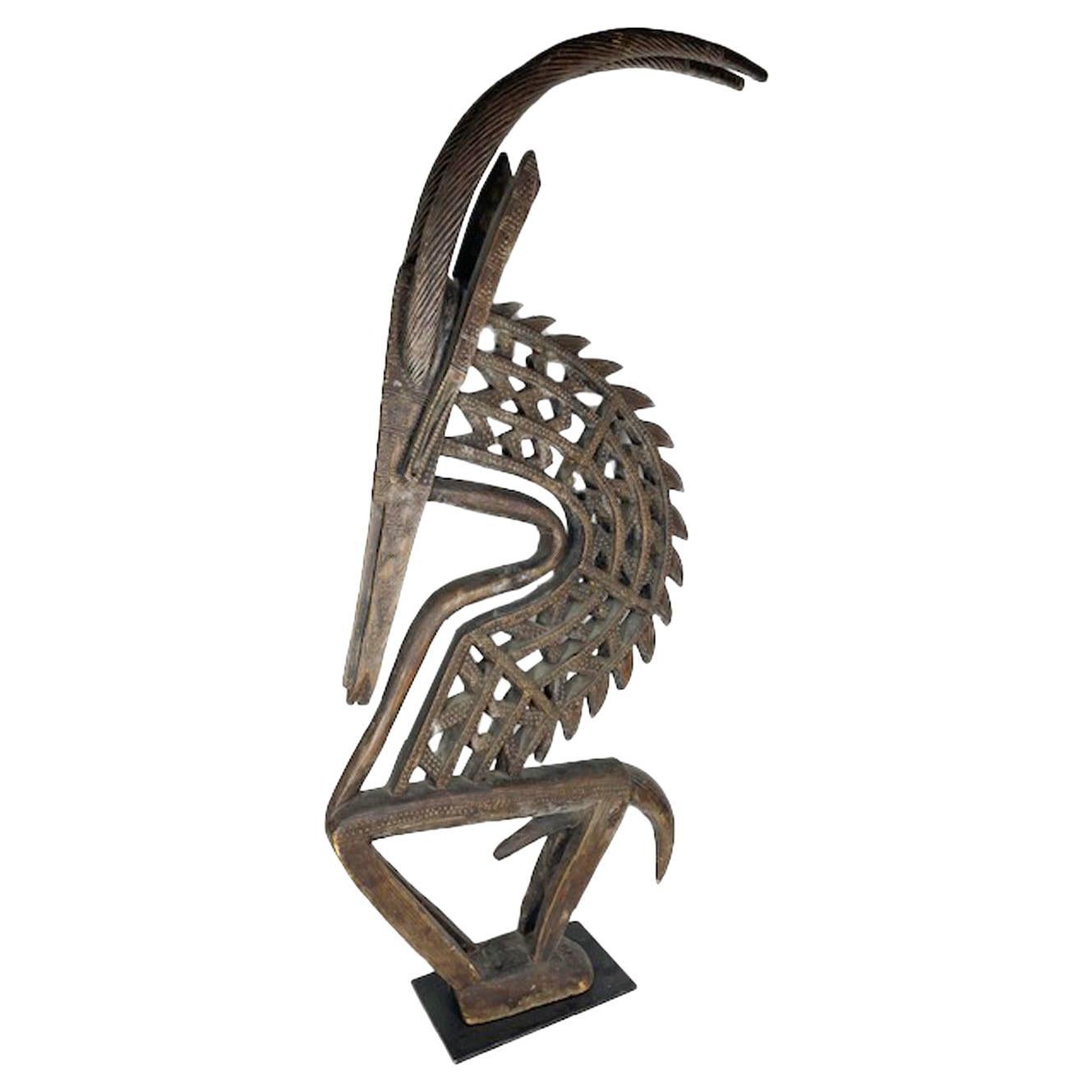 Chi wara is a ritual headdress used by the Bambara people in Mali. Portrayed as both male or female figures Chi ware is associated with agriculture. This large male example has a strong and striking cut-out triangular motif with large curved spiral