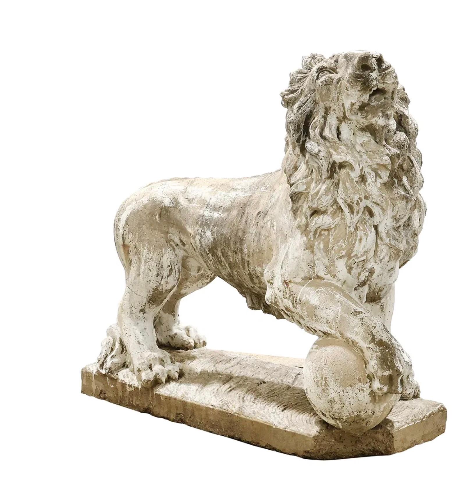 Impressionnant et imposant, ce lion gardien en pierre moulée du début du XXe siècle est sculpté en position debout, la gueule ouverte et la patte posée avec assurance sur un orbe, symbolisant la force et la protection. La statue est montée sur un