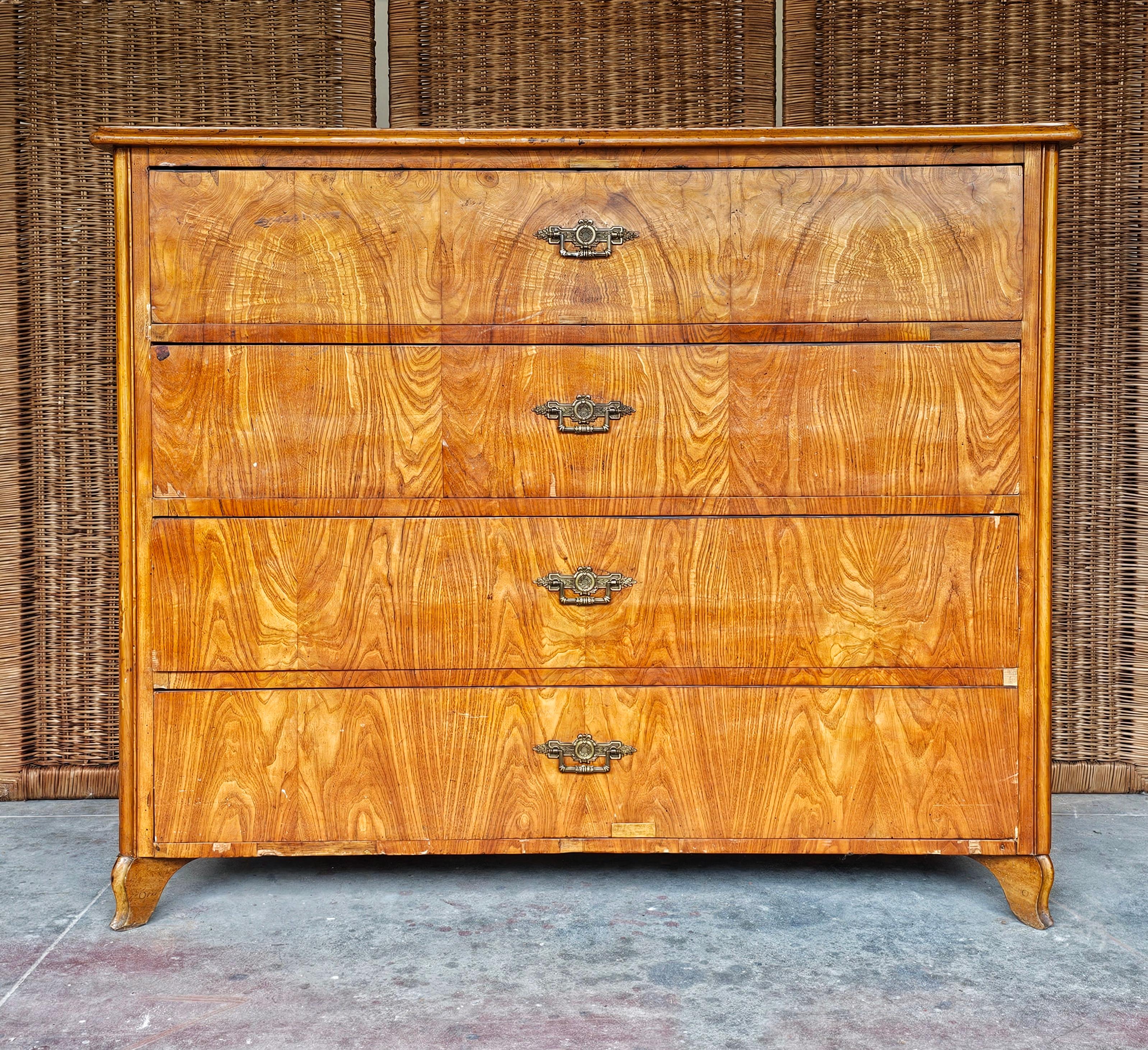 Dans cette annonce, vous trouverez une spectaculaire commode ancienne. Il comporte 4 grands tiroirs et une quincaillerie en laiton. Cette pièce est réalisée en bois, avec un placage présentant un riche grain de bois. Fabriqué en Autriche dans les