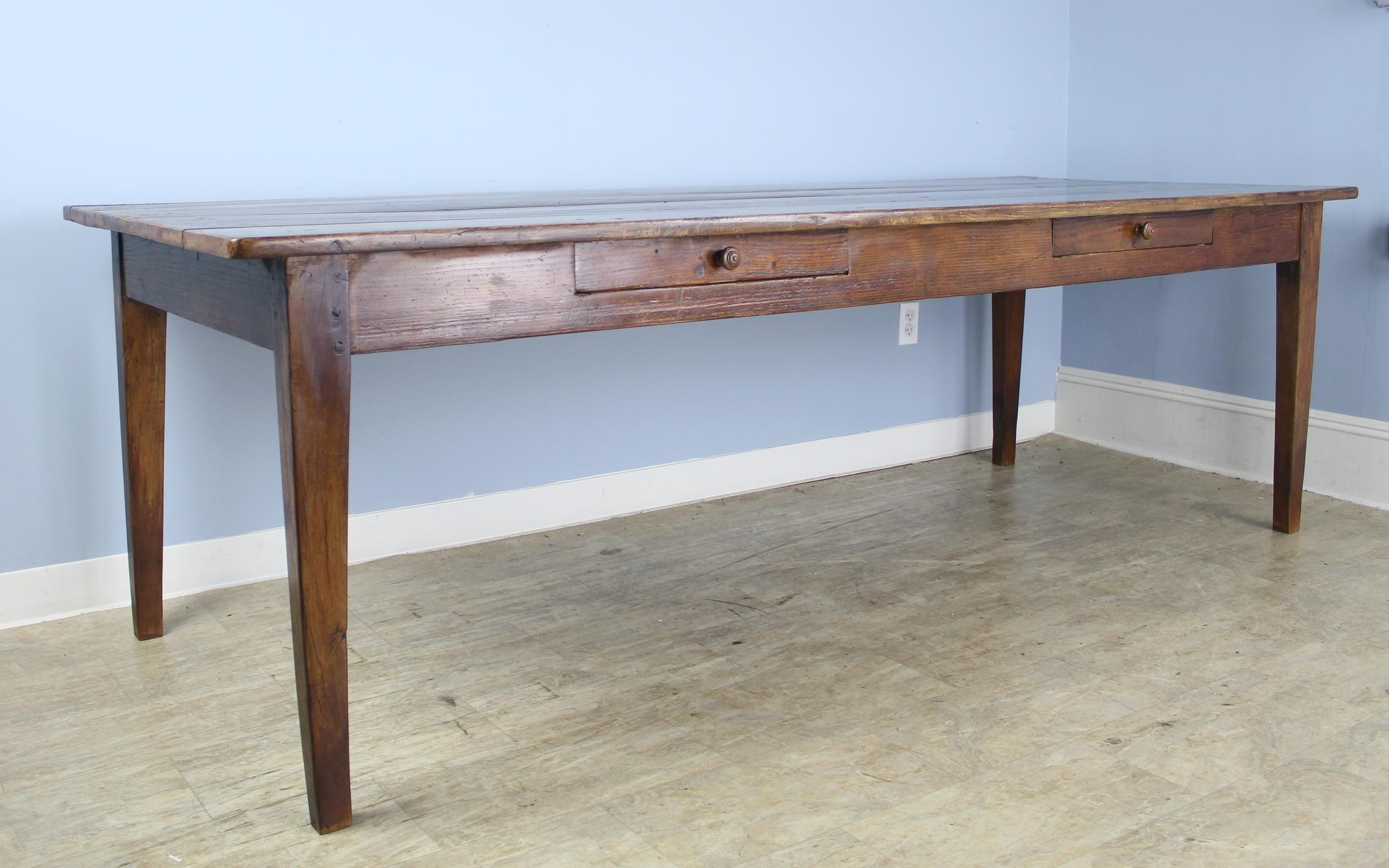 This long table is also wide, providing excellent space for dining. It is very good looking, with lovely mellow grain, little distress, and strong tapered legs. The two drawers on one side add a note of whimsey. Apron height is a good 24.75