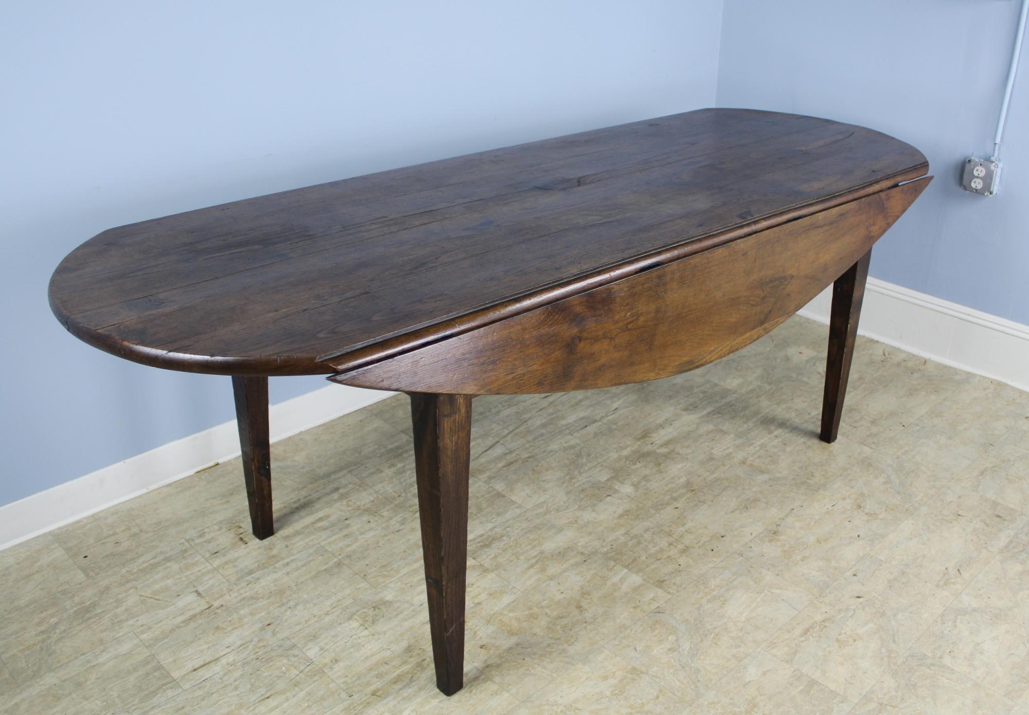 This splendid long chestnut table is full of country antique details. From the uniquely handcut thick top, to the original pullout / pull-out iron supports under the drop leaves, this table is like no other we have ever had in our store. Excellent