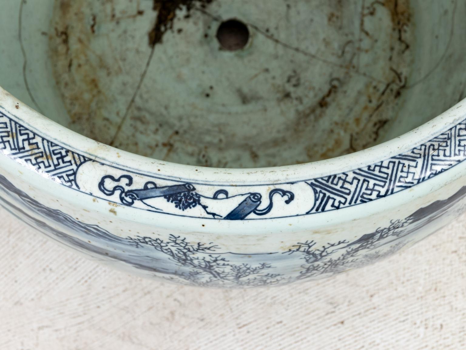 Large antique blue and white cache pot decorated with stylized figures in a landscape, circa 19th century or earlier. Although this piece has been mended more than once it stands as a testimonial to its beauty and the love its previous owners had