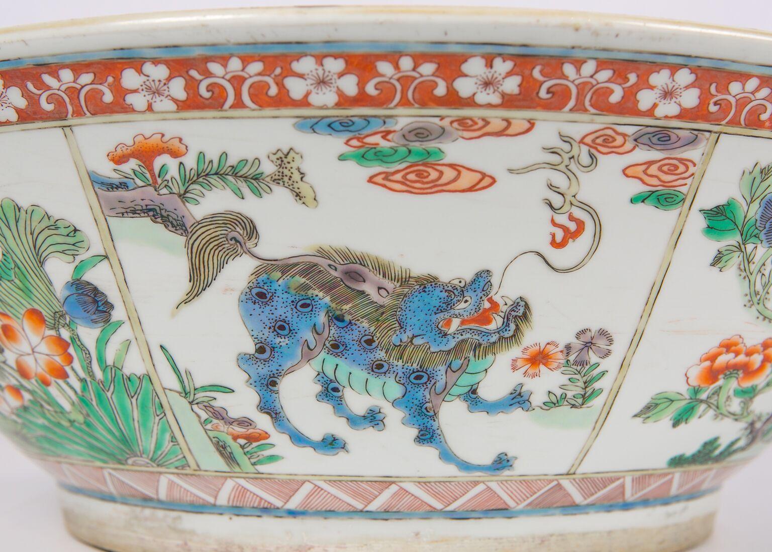 We are pleased to offer this enormous Chinese Famille Verte low bowl. It is richly painted with mythical animals and lovely flora. The outside wall is evenly divided into eight panels, each of which is hand painted with colorful patterns. The artist