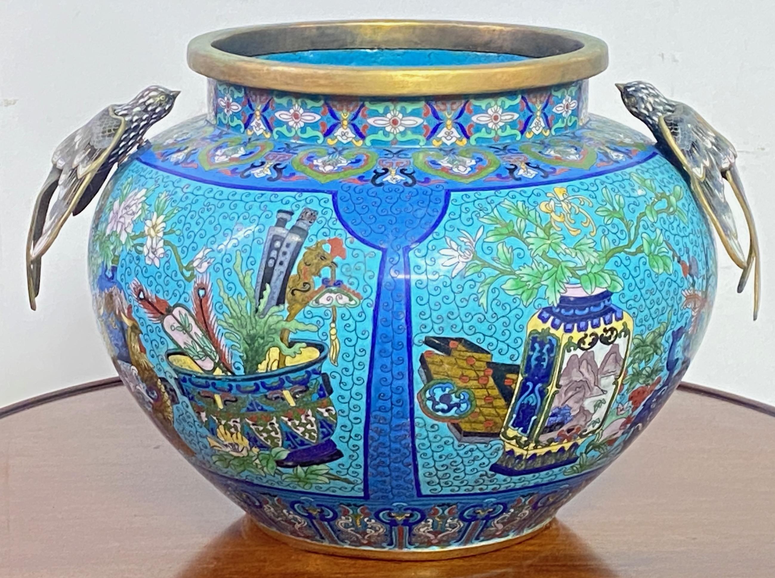 A large exceptional antique Chinese cloisonne pot or urn. Showing a very detailed hand crafted work of enameled art with flowers and animal designs around the pot. On each shoulder, there is a beautiful detailed cloisonne bird.
In remarkable antique