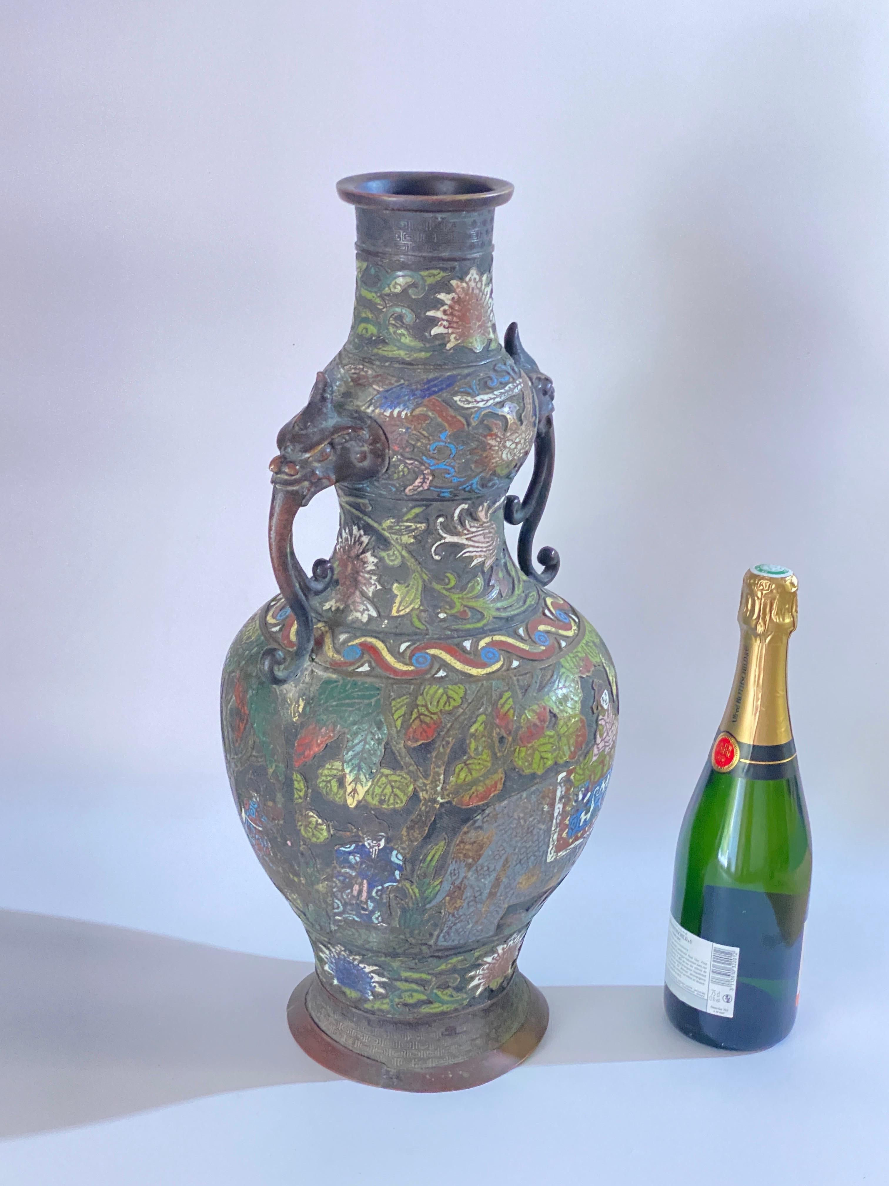 Grand vase en bronze émaillé cloisonné et champlevé, datant de la fin du XIXe siècle et datant de la dynastie Qing, vers 1890. Ce vase de style archaïque, doté de deux anses, est somptueusement décoré d'émaux colorés représentant des figures