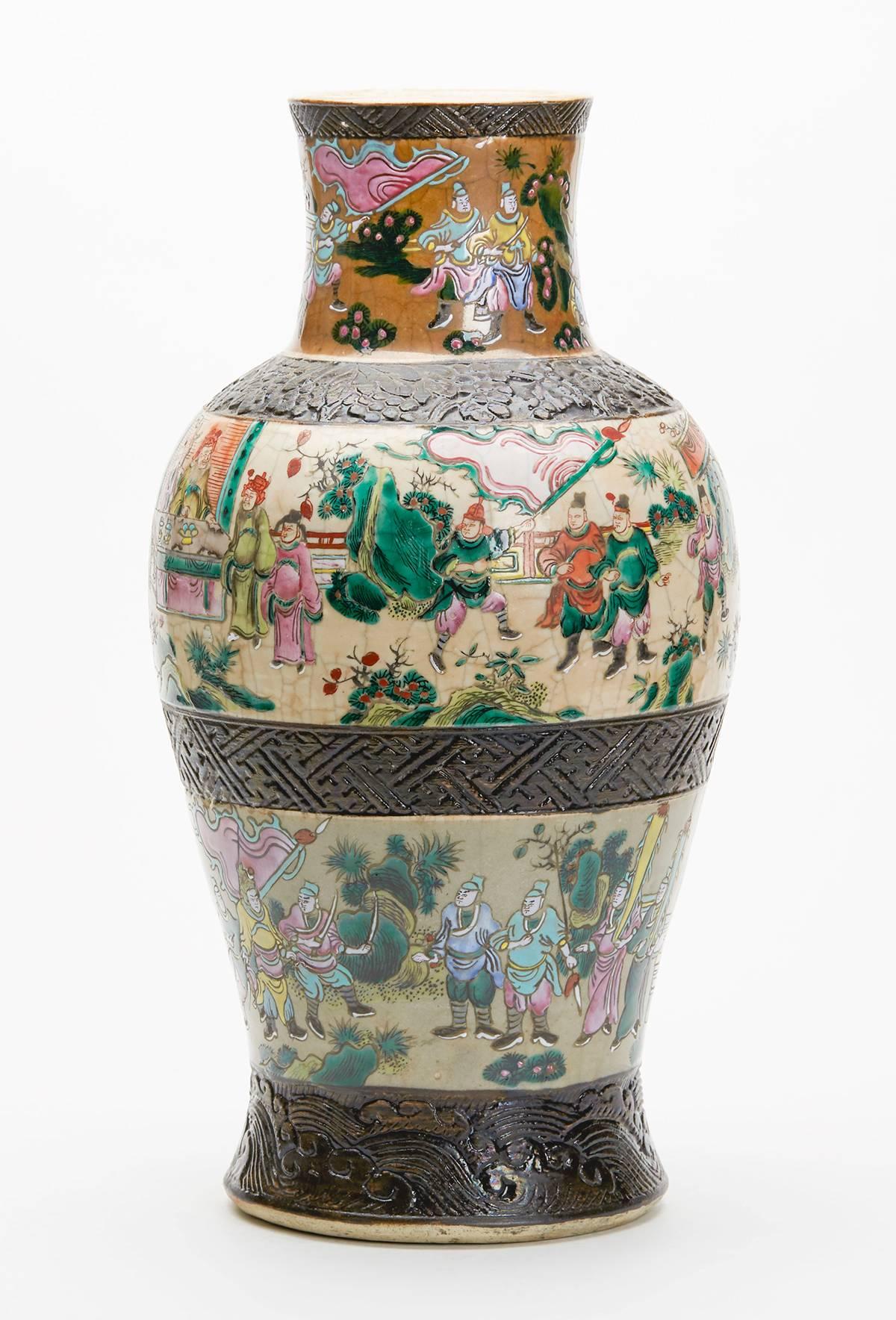 A stunning and large antique Chinese vase hand painted in the Famille rose palette over a craquelure ground with moulded bands separating the painted scenes into three continuous scenes. The painting is exceptional with a battle scene around the