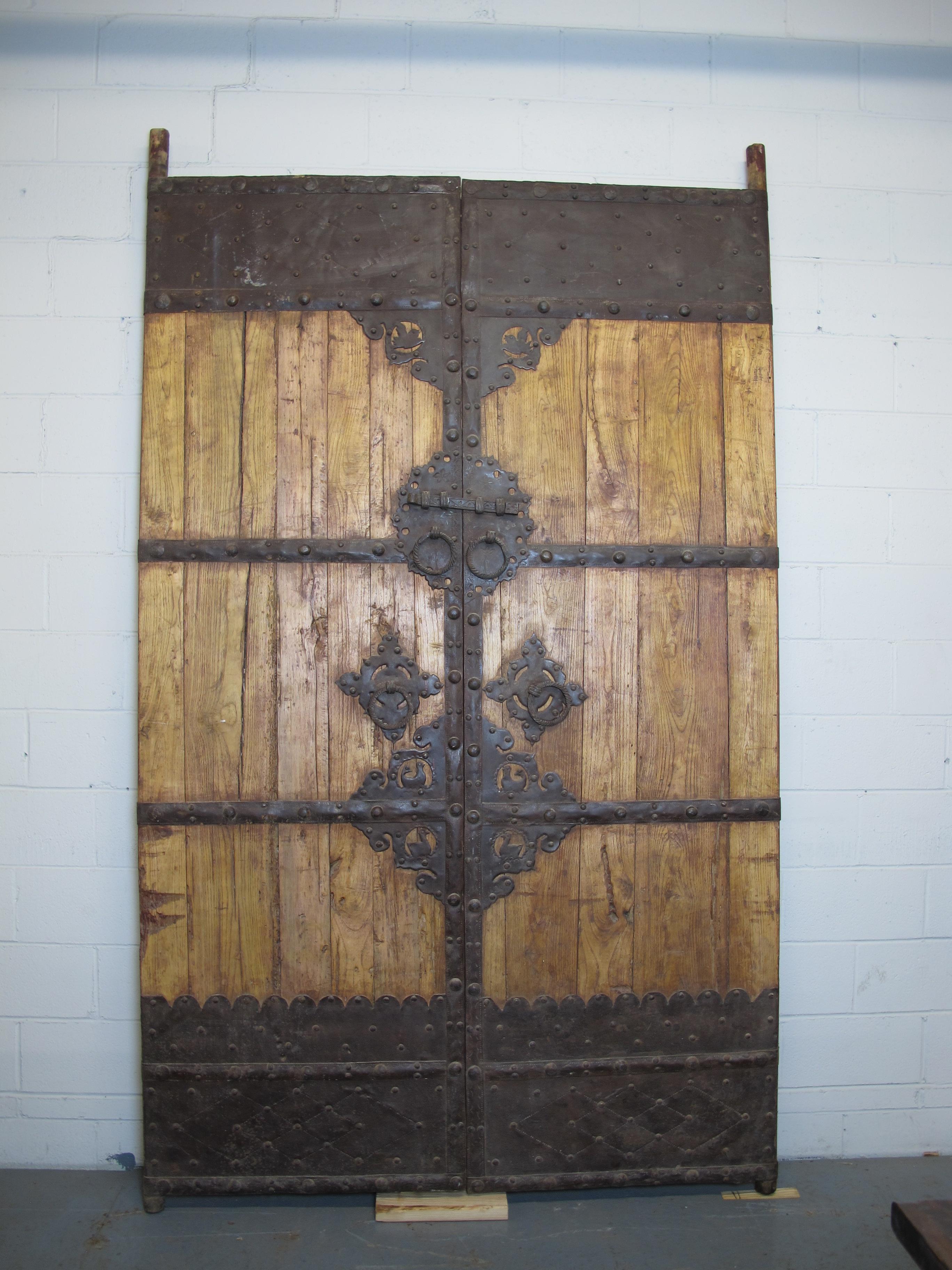 This magnificent antique Chinese door still has its original iron hardware. The iron work in the center of this door is stunning, birds, door locks and ring, decorative patterns. It is very heavy and in excellent condition. Looking for a door that