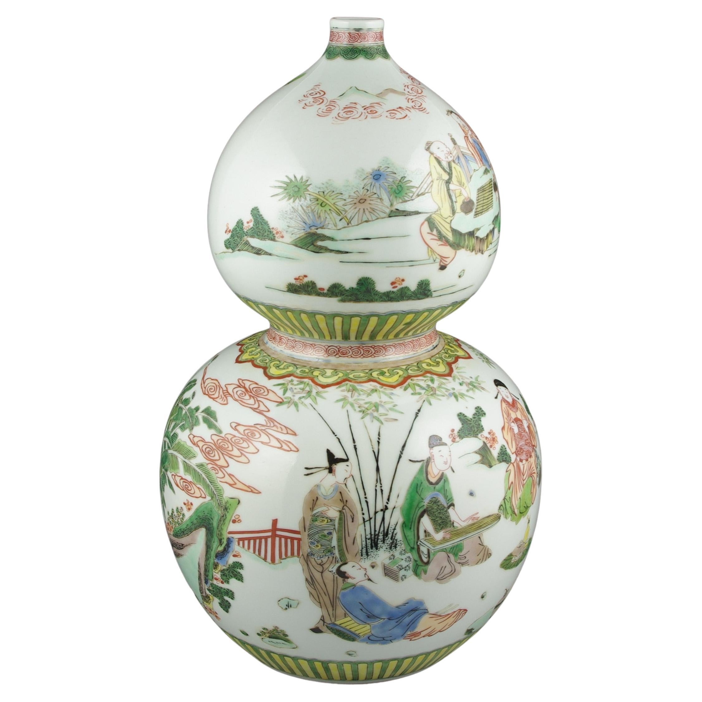 Un grand et splendide vase chinois ancien, fabriqué dans la forme caractéristique d'une double gourde, présente une peinture à la main méticuleuse dans la palette vibrante de la famille rose de Fencai. Le vase représente des personnages parés de