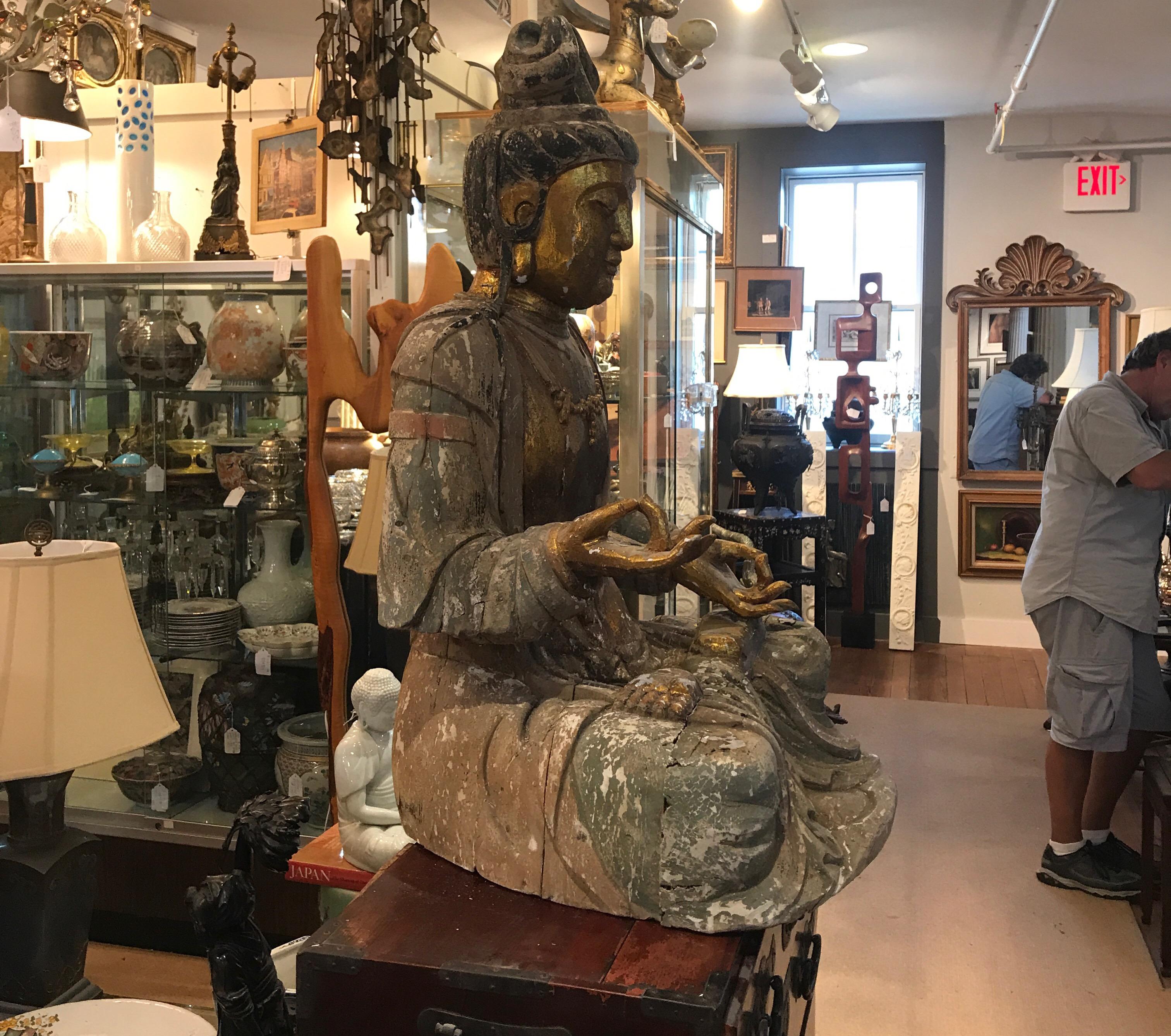 A large hand carved hardwood Buddha, China, circa 1900. The sculpture with original old and worn finish showing wood shrinkage and some lines due to expected age and originality.