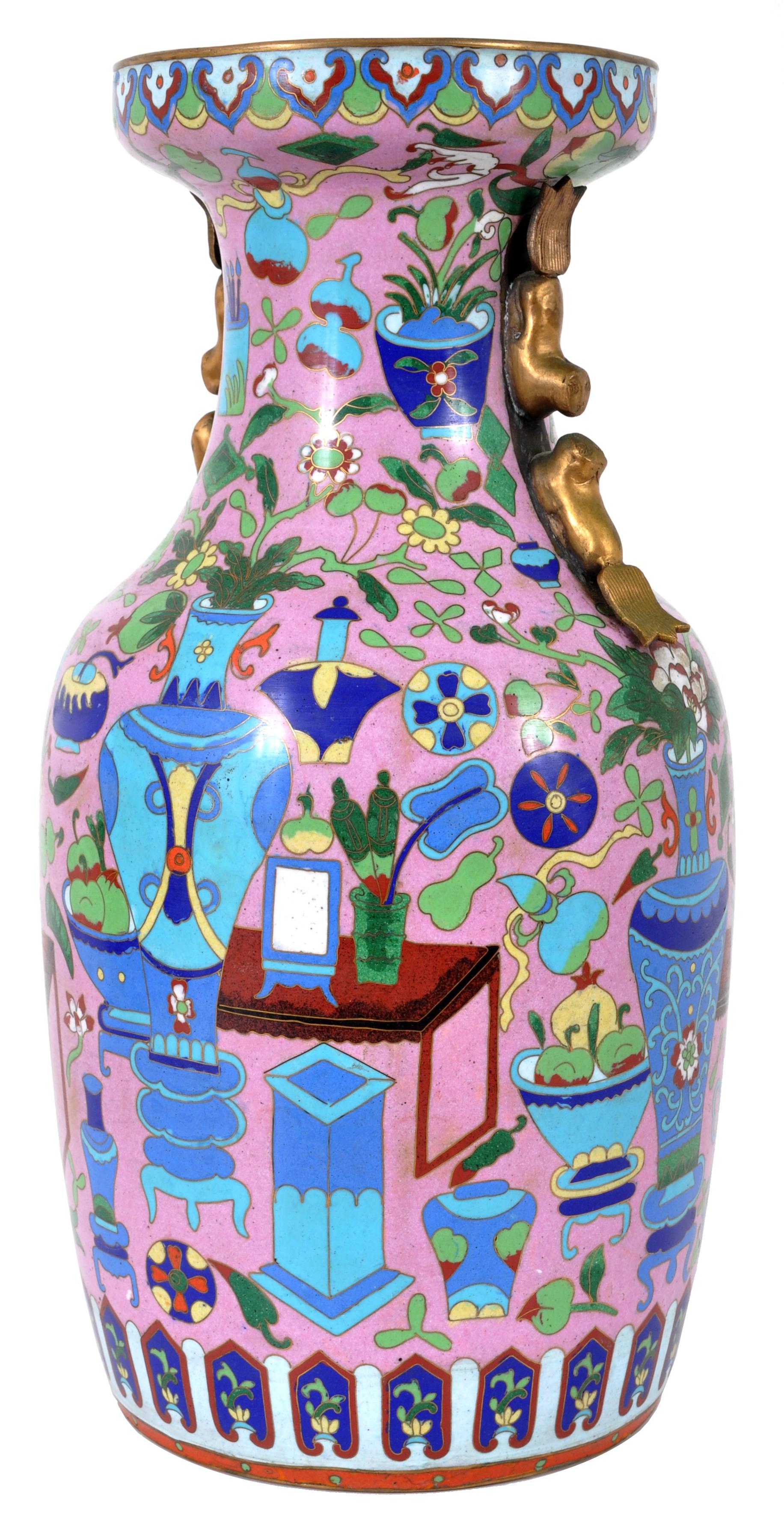 A large and fine antique Chinese Cloisonné vase, circa 1920. The vase decorated with lappets to the top and profusely decorated with vases, scholars objects, furniture and flowering urns as well as other geometric devices. The vase having a band of