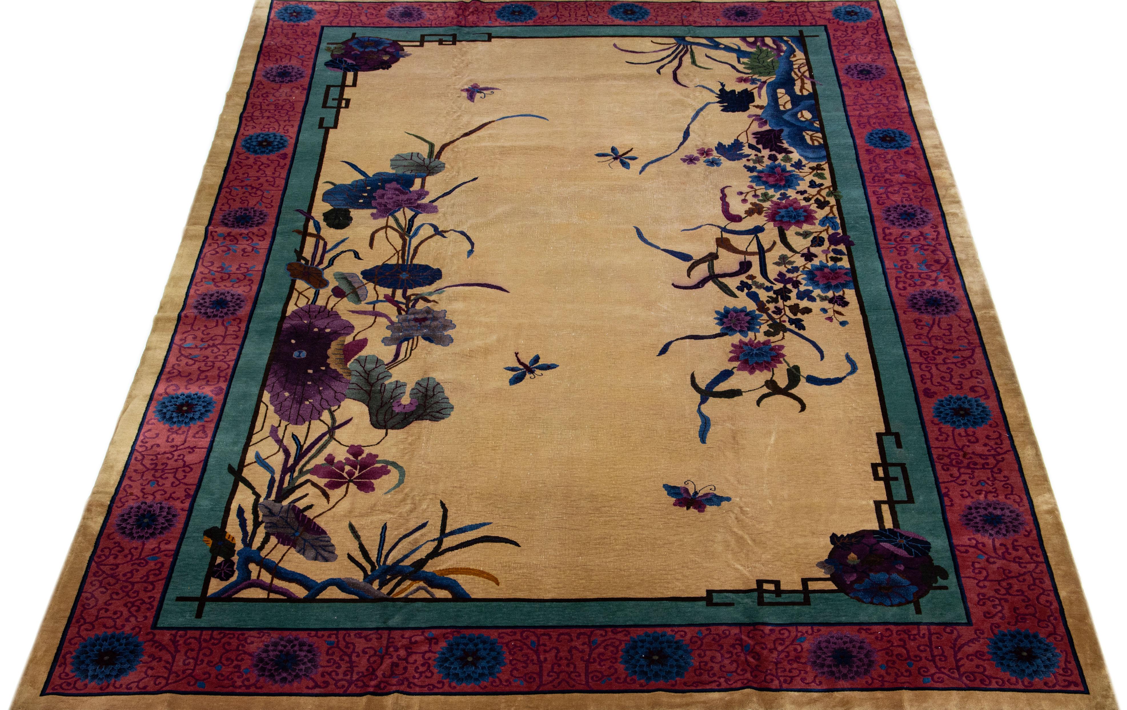 A beautiful oversize Chinese Nichols hand knotted wool rug with a tan field red and green frame, and multi-color accents in all-over Chinese botanical designs.
This rug measure: 11' 8