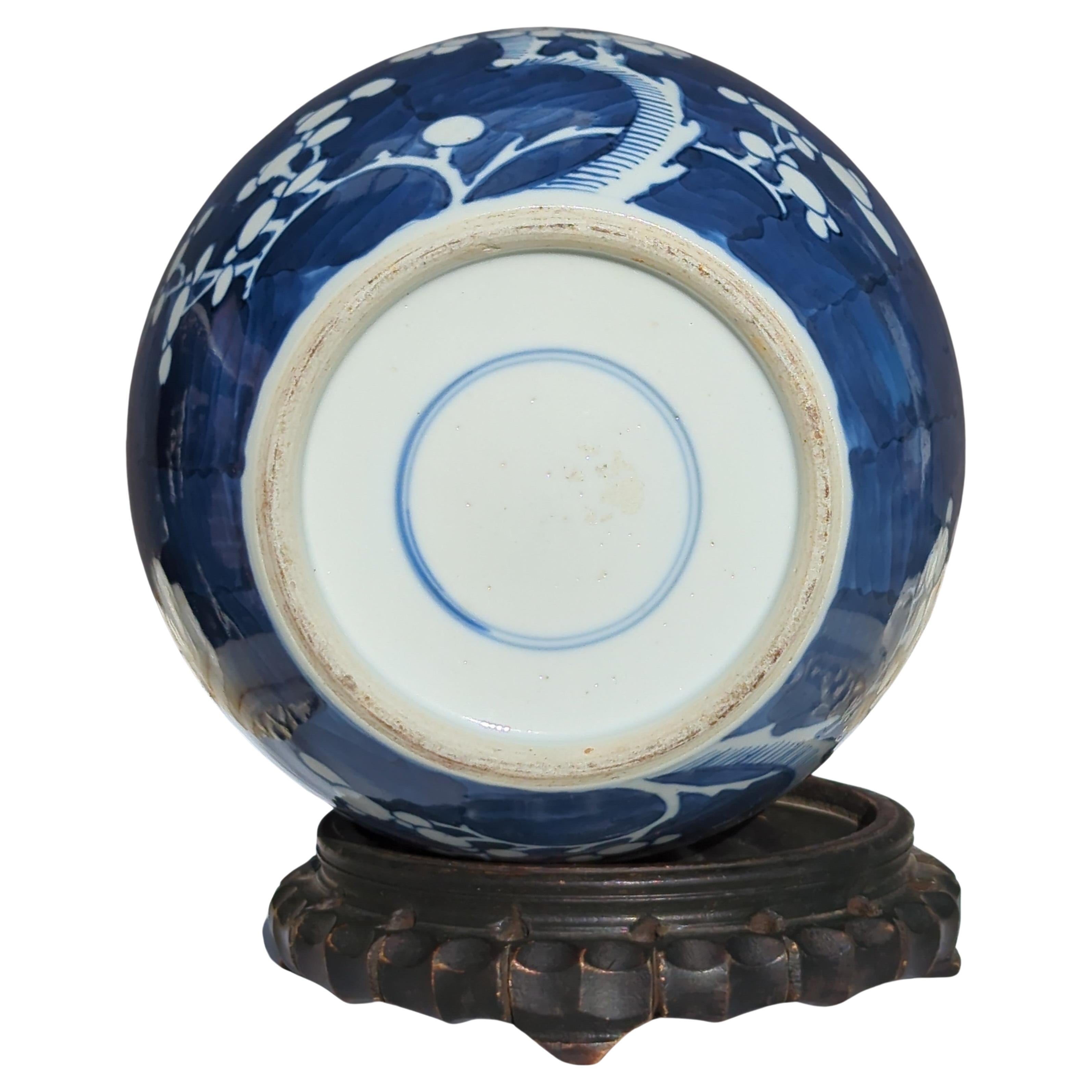 Antique Chinese late Qing dynasty blue and white ginger jar, reserve decorated in underglaze blue and white, with blooming prunus branches on underglaze blue wash ground, and double circle mark in underglaze blue within the footring

Comes with