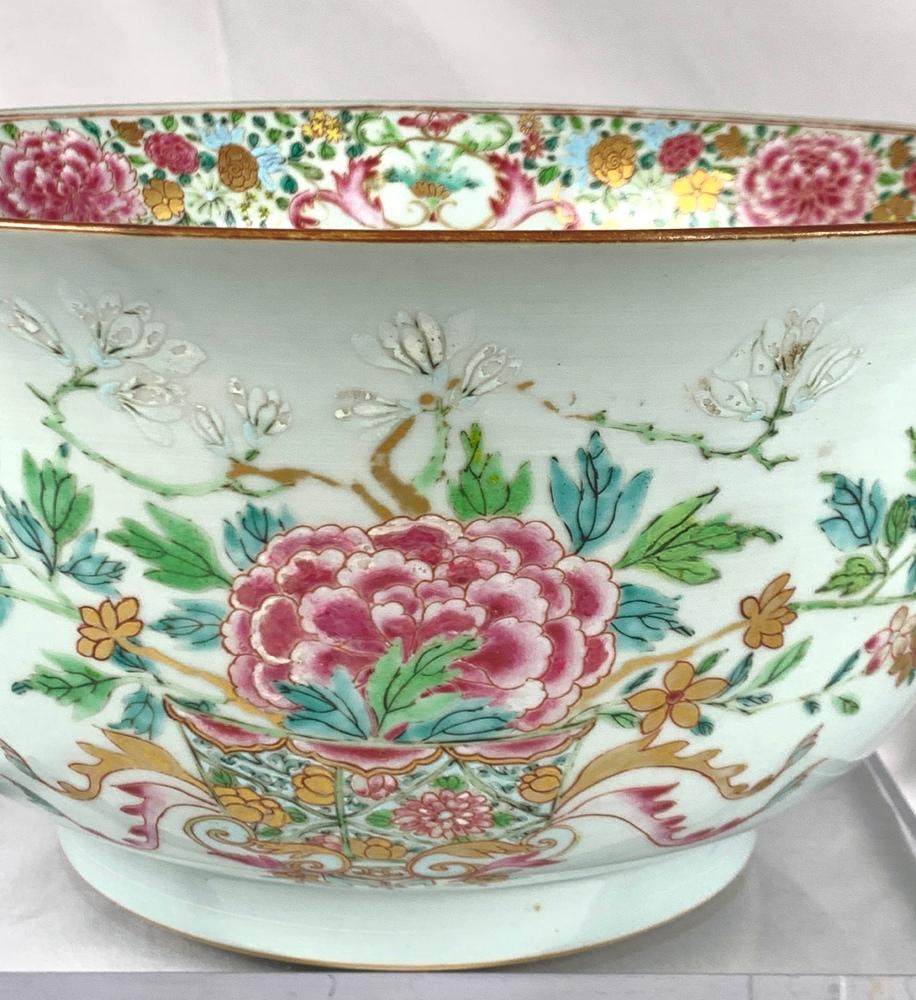 Diese exquisite Schale aus chinesischem Exportporzellan aus dem 18. Jahrhundert wurde in der Qianlong-Ära um 1770 mit farbigen Emaillen in der Famille Rose-Palette handbemalt.
Rosa Pfingstrosen in voller Blüte werden in eleganten Blumenkörben