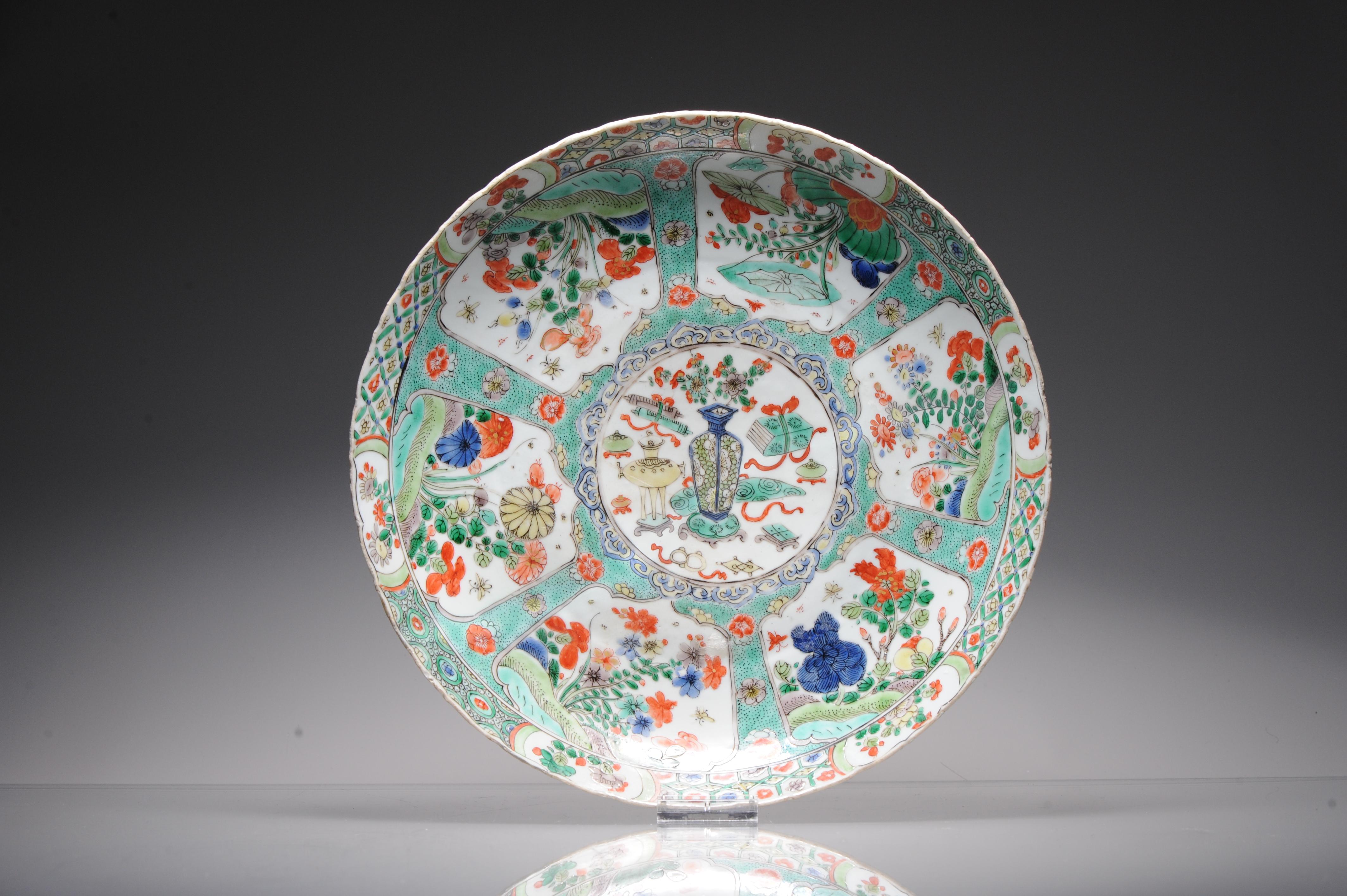 Description

A LARGE 'CHINESE VERTE' EXPORT PORCELAIN DEEP DISH
Kangxi period
Painted with enamels of the famille verte palette with reserves of flowers, Trees and in the centre a flower basket and various objects. The exterior walls with