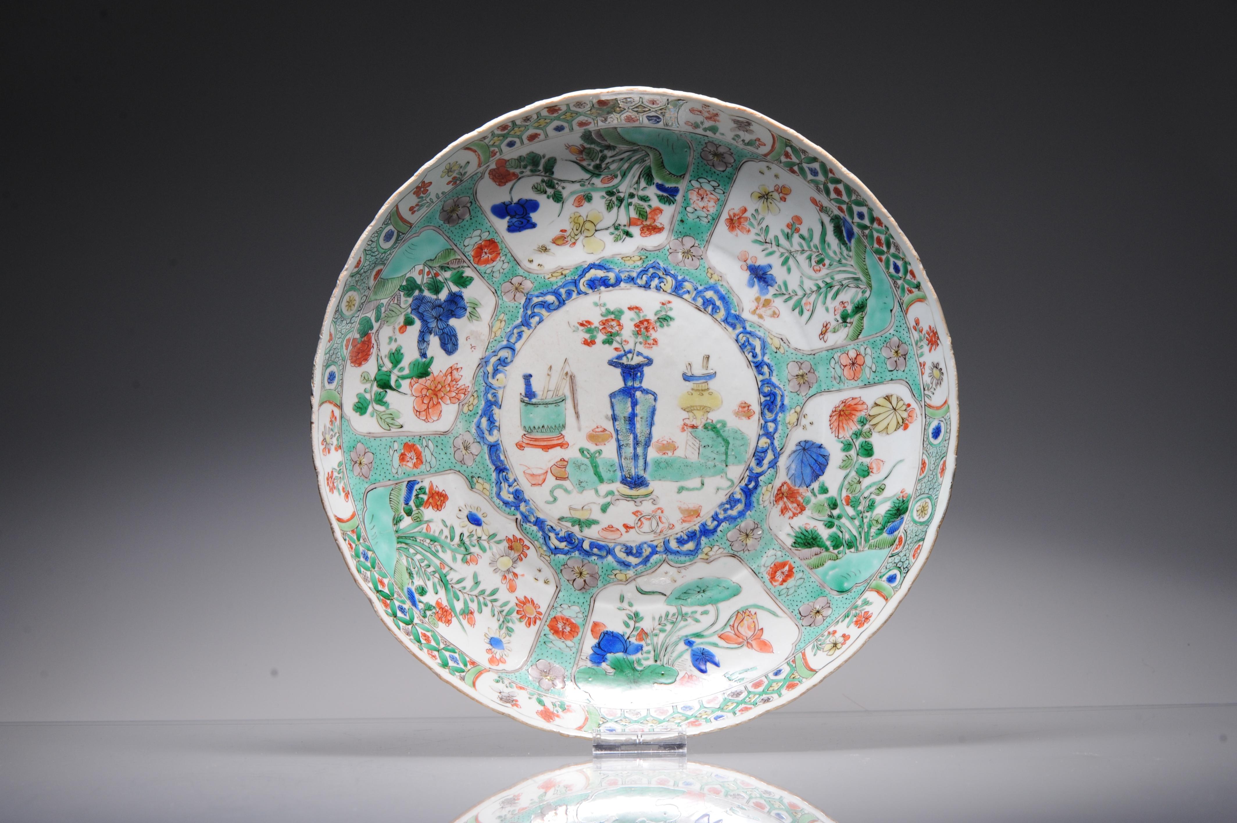 Description
A Large 'Chinese Verte' export porcelain deep dish
Kangxi period
Painted with enamels of the famille verte palette with reserves of flowers, Trees and in the centre a flower basket and various objects. The exterior walls with