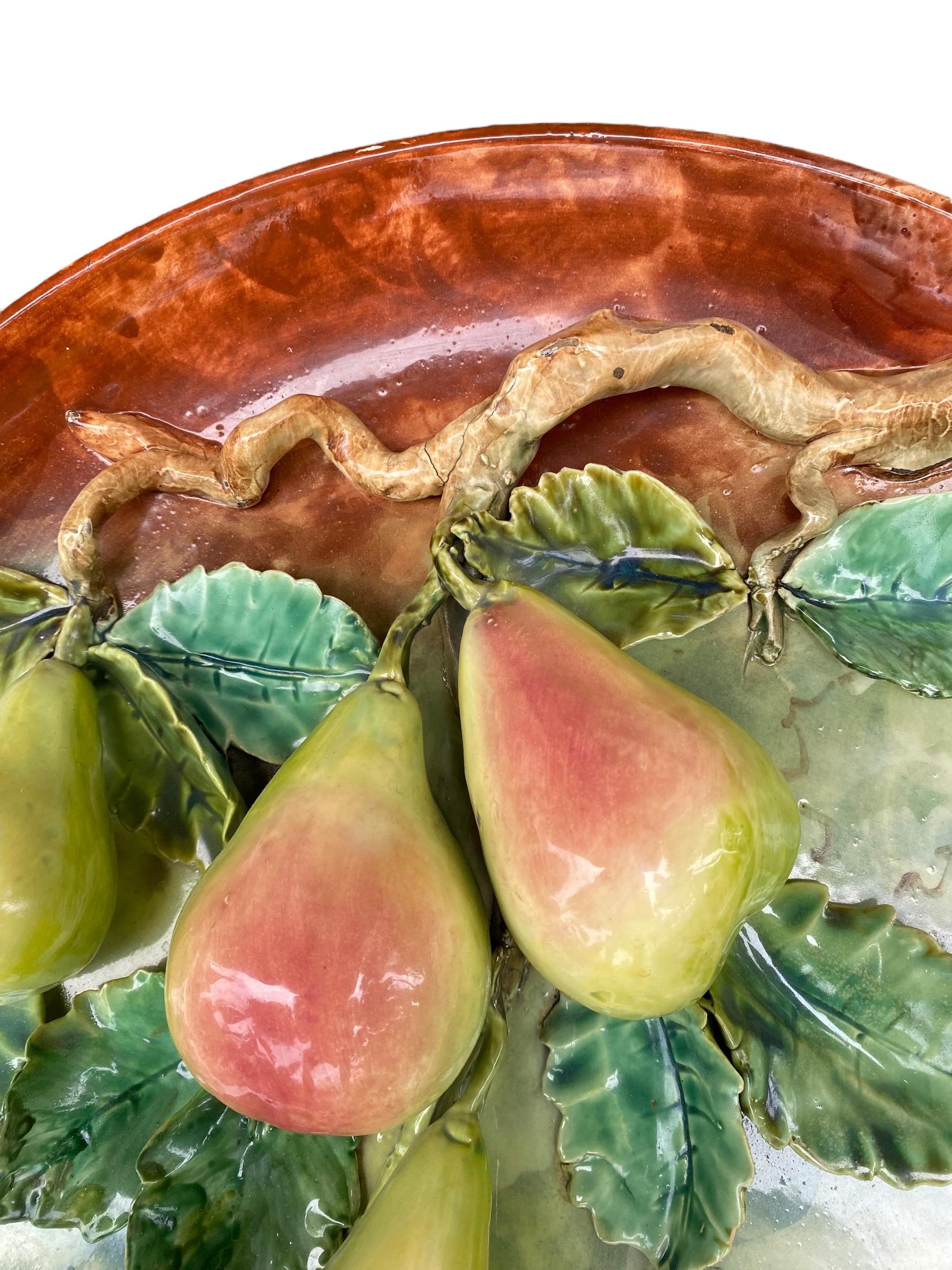 A stunning Large French majolica wall platter, late 19th century, with high relief decoration of colored pears dangling from a vine.

At the end of the 19th century, Longchamp and Fives-Lille produced fruits platters of all kinds in a range of