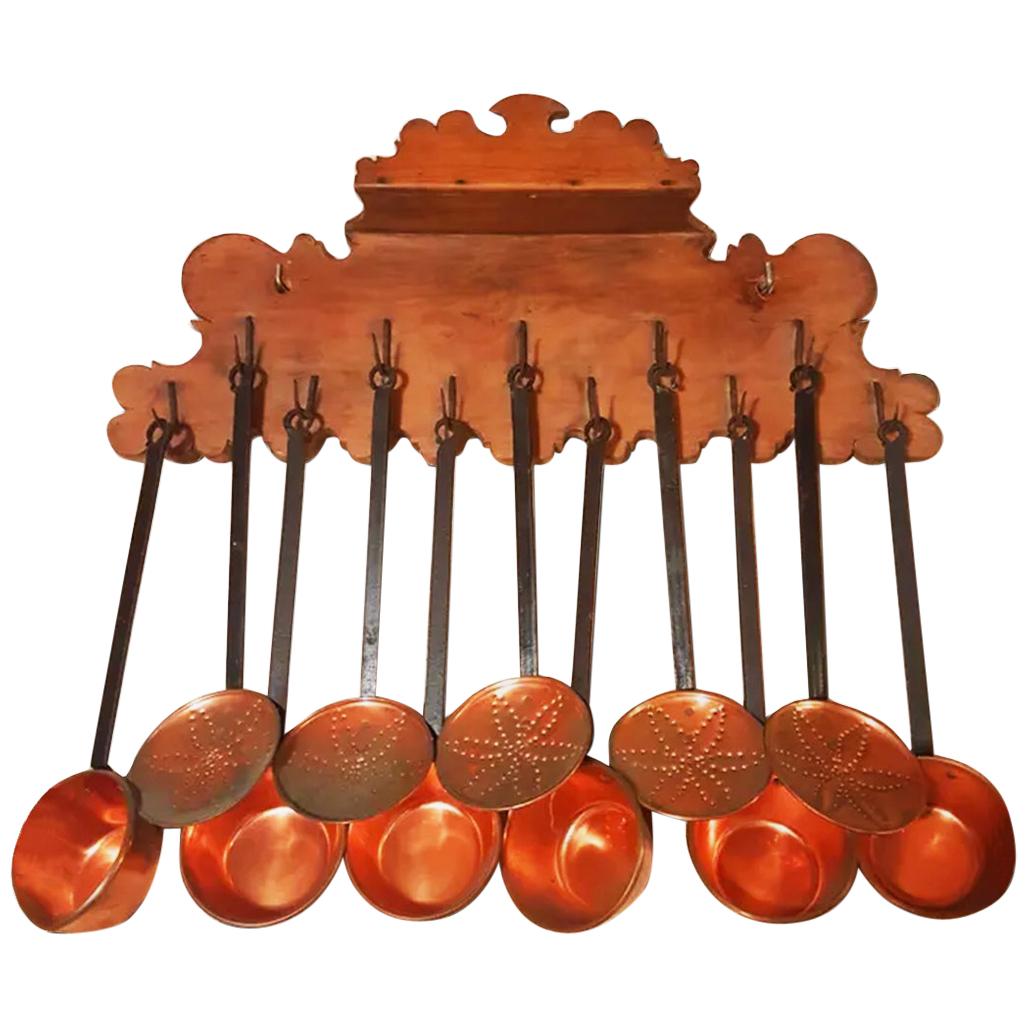 Spectacular pice

Very large size 75 cm
The lot is made up of:
1 wooden and wrought iron hanger (19th century)
 11 copper and iron pans and skimmers (early 20th century)

Antique copper and wrought iron kitchen utensils with walnut wood pendant,