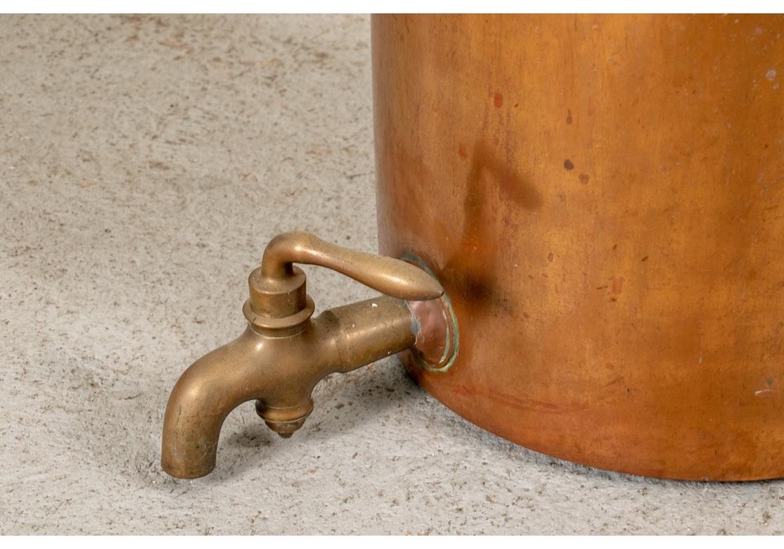 Un très authentique distributeur antique en cuivre lourd en parfait état d'origine. Avec des poignées verticales en fer riveté et un grand bec verseur en laiton avec poignée. Le distributeur est vendu à titre décoratif et n'est pas vendu pour être
