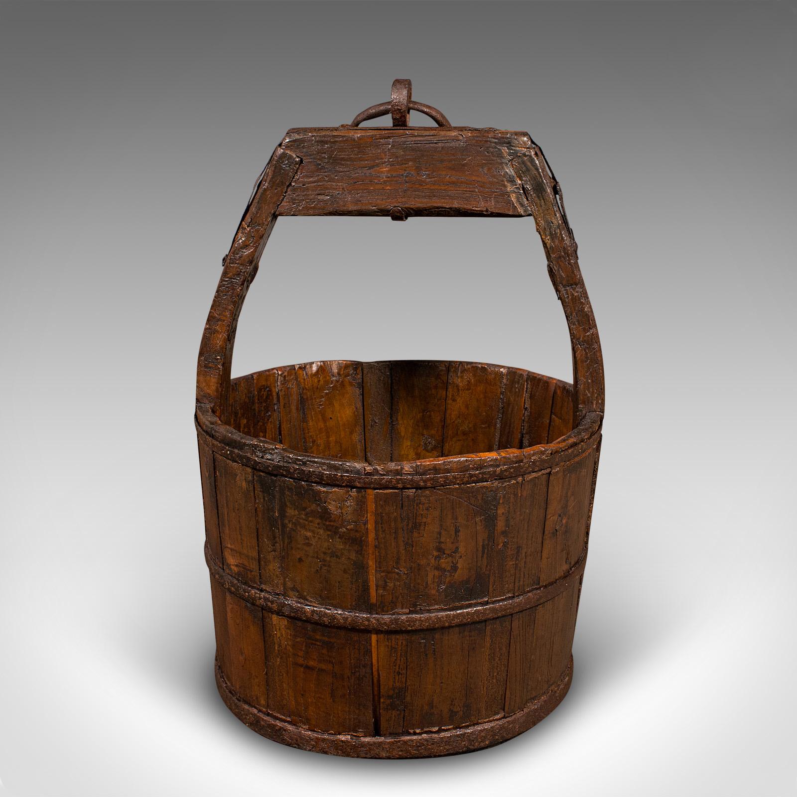 Se trata de un magnífico cubo de pozo antiguo de la época georgiana, que ofrece un encanto rústico y un uso versátil, circa 1800. Esta antigüedad, fabricada por el propietario, presenta una artesanía agradablemente ingenua y una rica pátina