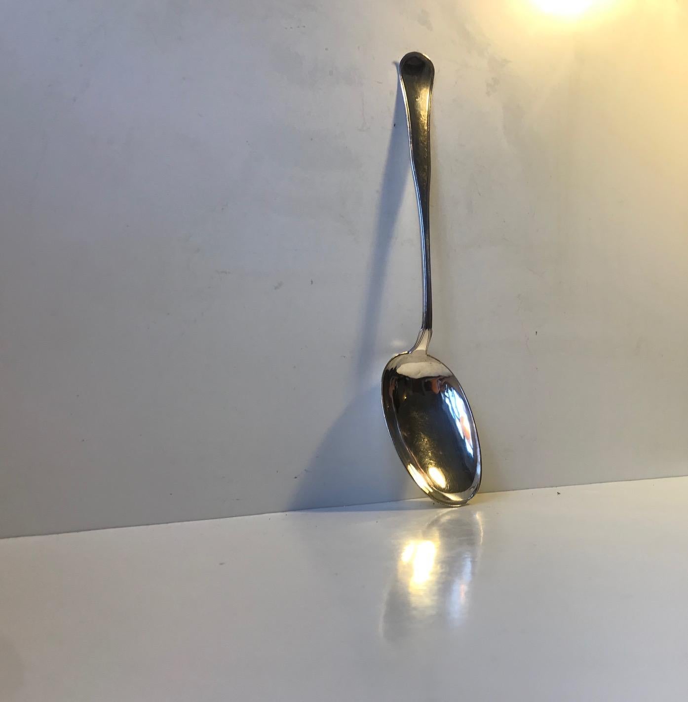 Large serving spoon in silver. Length: approx. 33 cm (12.5 inch). Weight: 113 grams. Plain design. Hallmarked sterling silver with the 3 Towers of Copenhagen. Designed and manufactured by Funck in the late 19th century Denmark. Fully hallmarked to