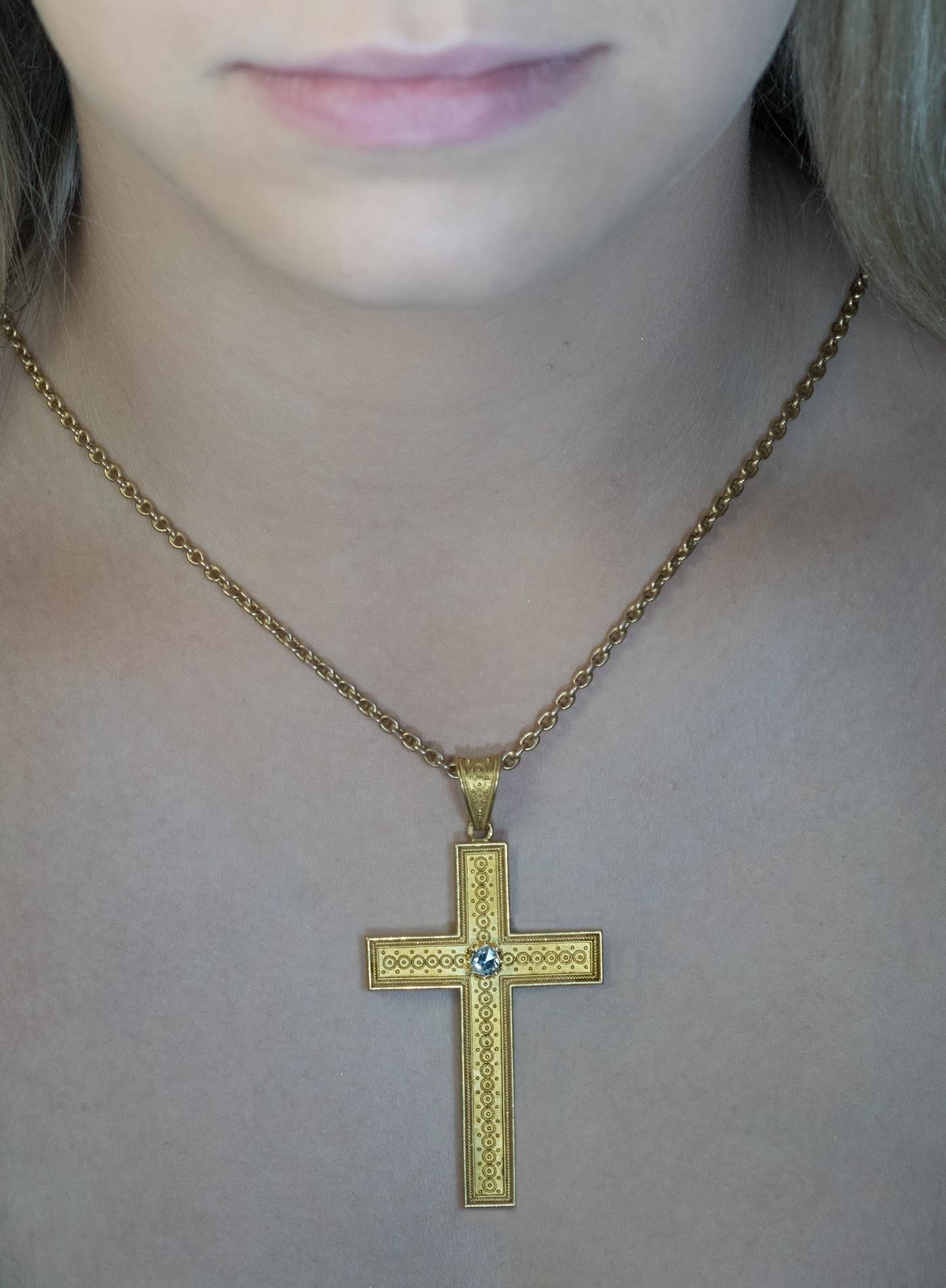 Austria, Vienna, circa 1880

A very fine quality, 14K gold hollow cross pendant is centered with a 5 mm old rose cut diamond. The arms of the cross are embellished with twisted gold wires (filigree) and granulations. These embellishments reflect