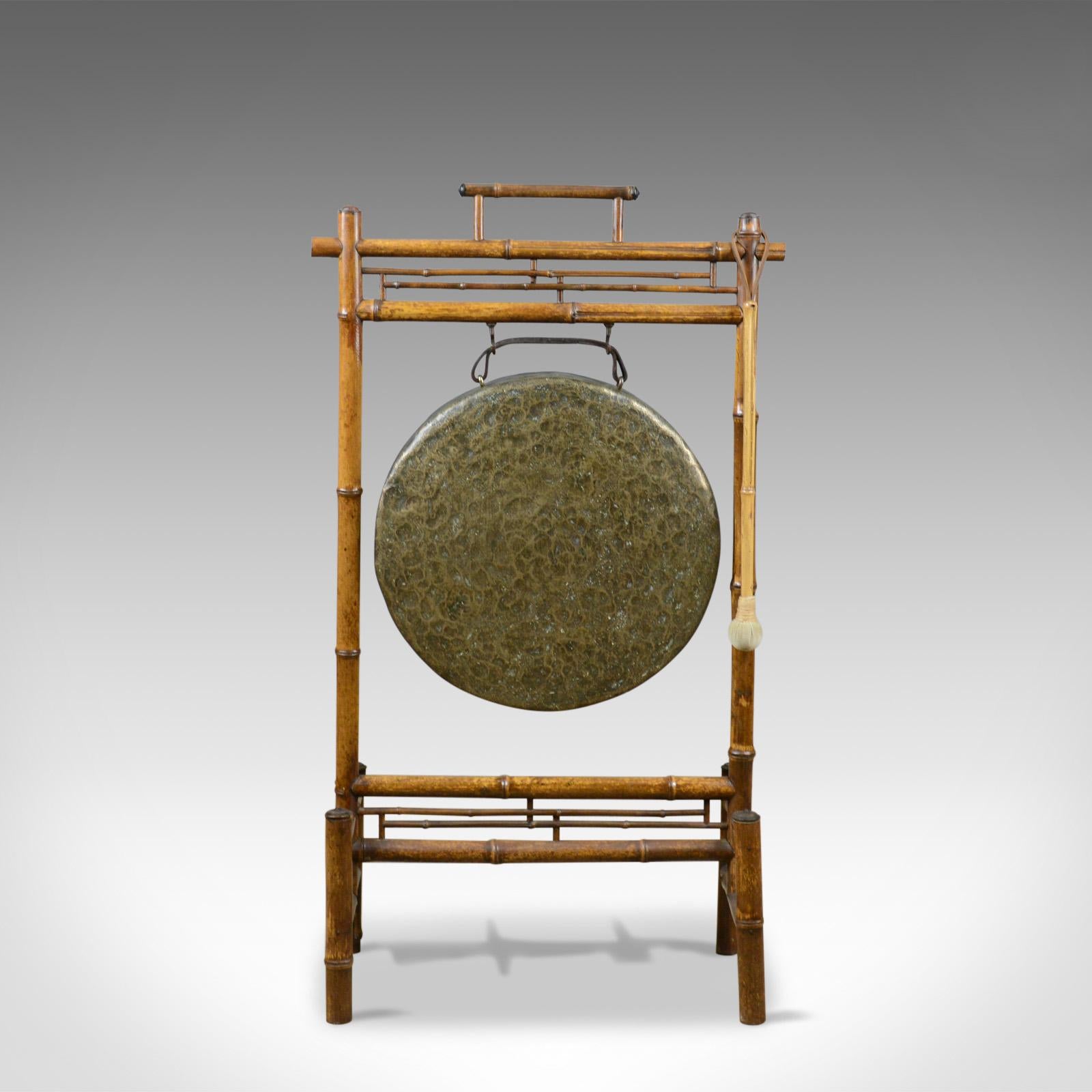 This is a large antique bronze dinner gong mounted in a bamboo frame. A Victorian instrument dating to the late 19th century, circa 1890.

Attractive bronze gong with natural aged patina
Hammered finish with deep sides
Leather hanging