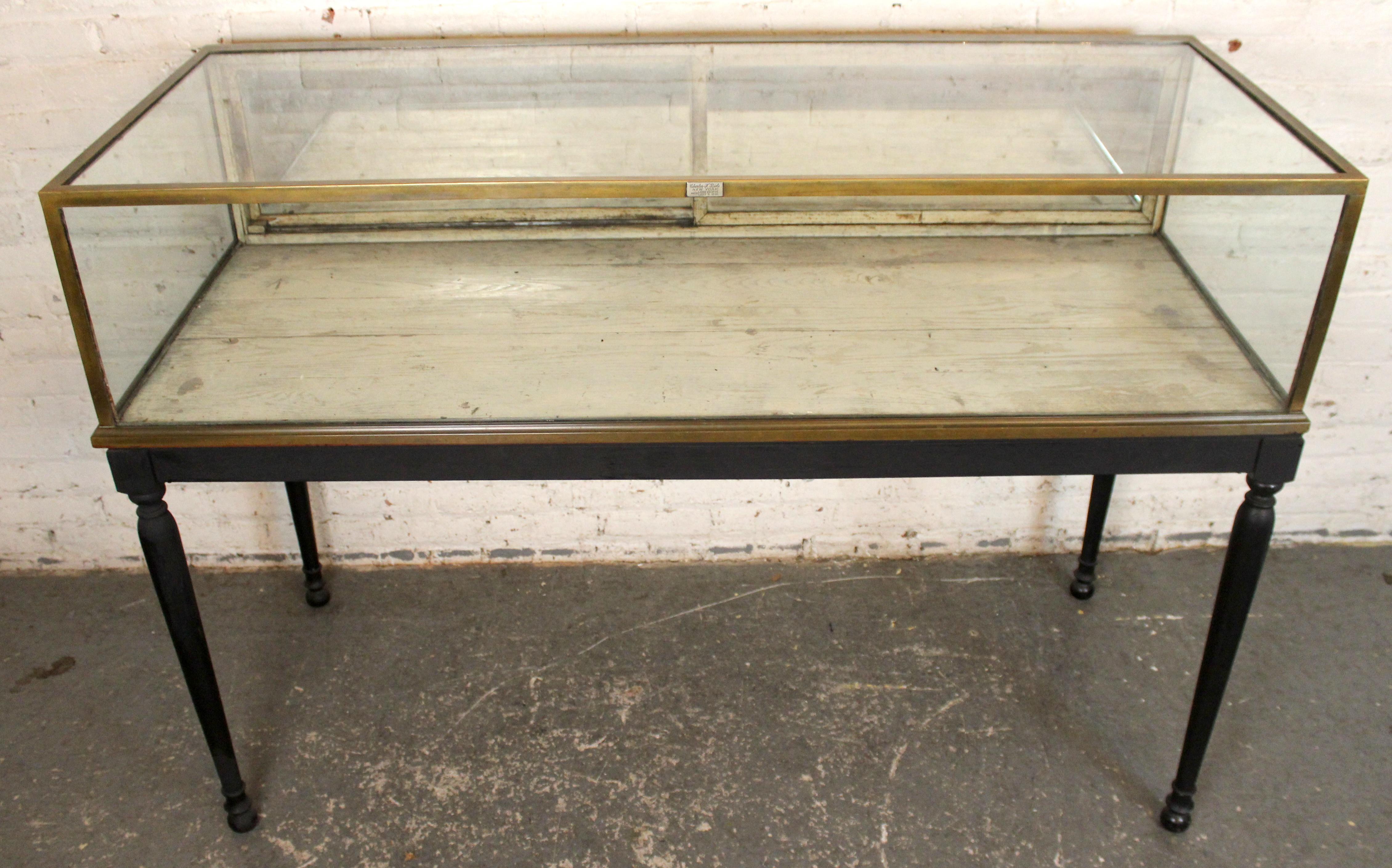 Rare grande vitrine ancienne de Charles F. Biele & Sons, fabricants renommés de vitrines de qualité muséale dans le New York du début du 20e siècle. Elle se caractérise par une armature en métal patiné, de larges panneaux de verre et des proportions