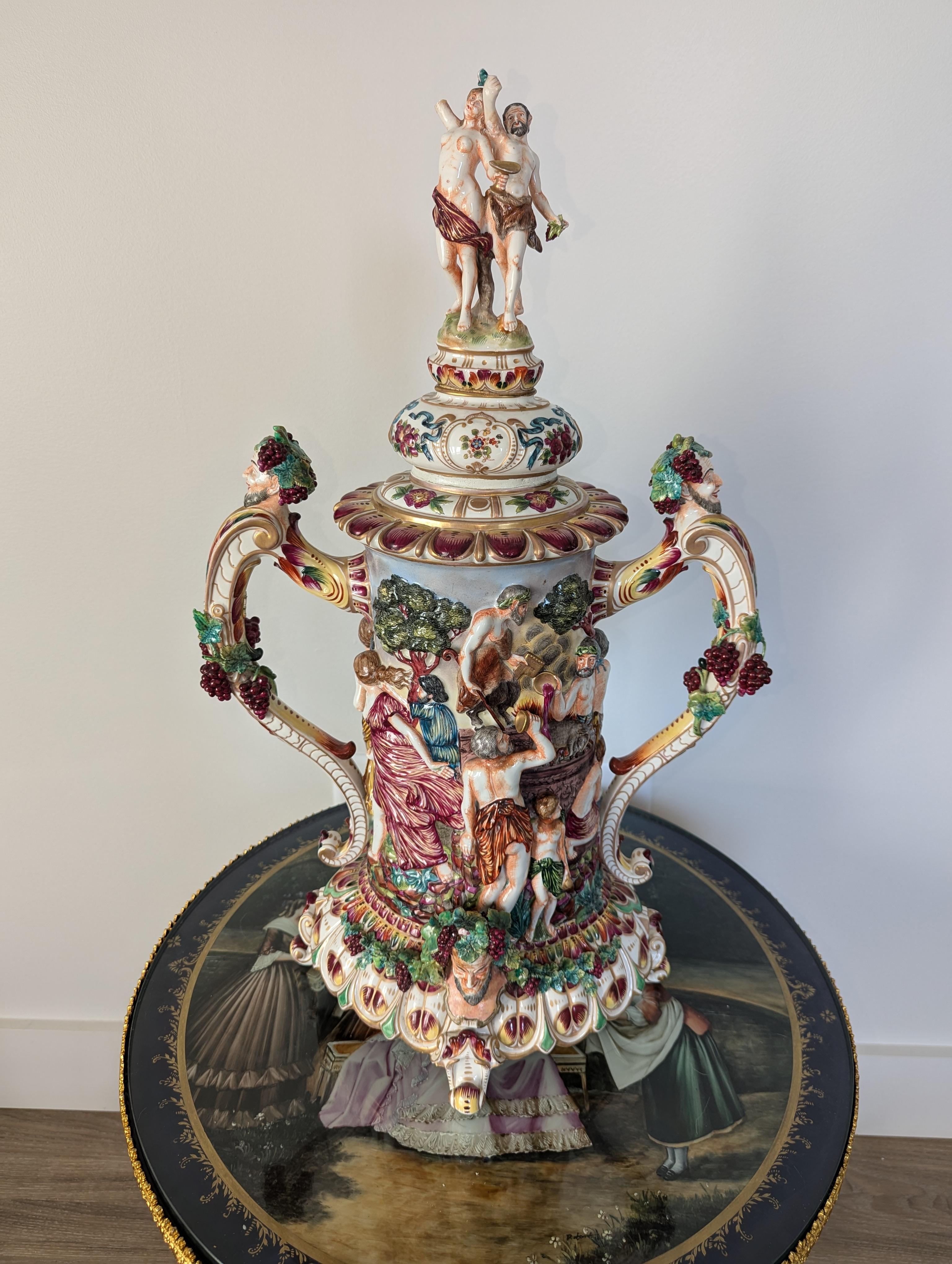 Questo splendido boccale di qualità museale è un capolavoro di porcellana di Capodimonte, realizzato a metà o alla fine del XIX secolo. Con un'altezza impressionante di 26 pollici e un diametro di 15 pollici, questo pezzo maestoso è un vero