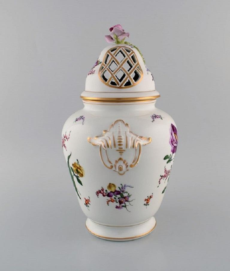 Large antique Dresden ornamental vase in hand-painted porcelain. 
Flowers and gold decoration. Rose in relief on the lid. Ca. 1900.
Measures: 37.5 x 30 cm.
In excellent condition.
Signed.