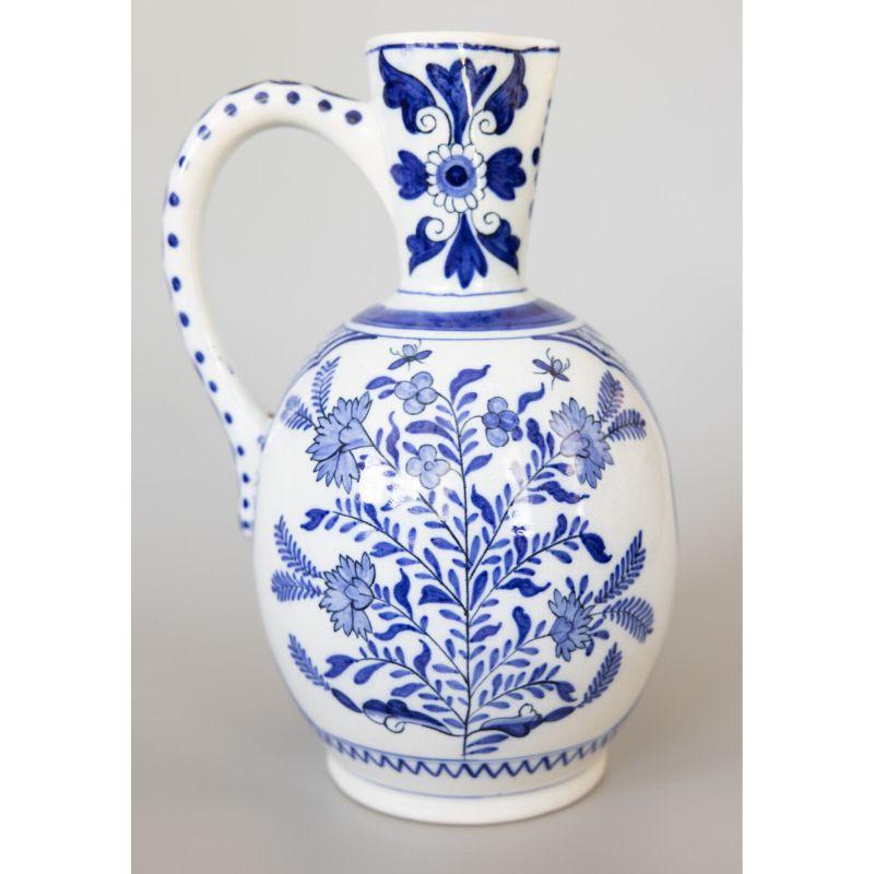 Magnífico cántaro antiguo del siglo XIX, en loza de Delft, de color azul cobalto y flores blancas, obra de Boch Freres Keramis, un conocido fabricante belga. Firmado en el reverso. Esta magnífica jarra de vino o aguamanil tiene un maravilloso diseño