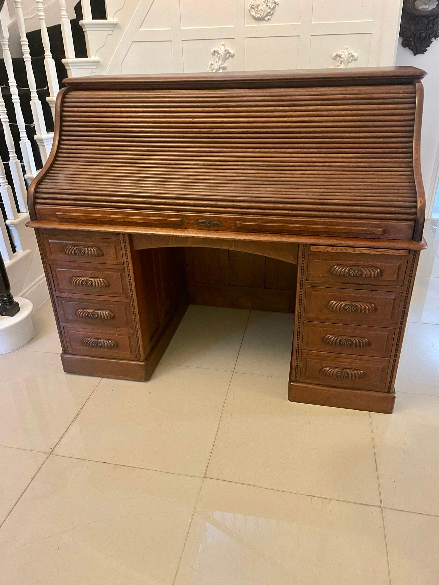 Large antique Edwardian freestanding quality oak roll top desk with fielded panels to all sides and back, quality swan neck tambour opening to reveal a fitted interior consisting of drawers, pigeon holes, pen trays, storage compartments and a