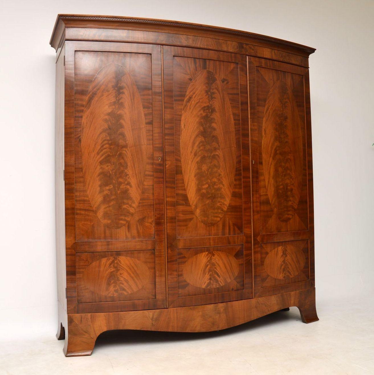 Wonderful quality antique Edwardian bow fronted large wardrobe in excellent condition and dating from the 1890-1910 period. Please enlarge all the images to see the many fine details. This wardrobe has a top cornice with a dental frieze, two outside