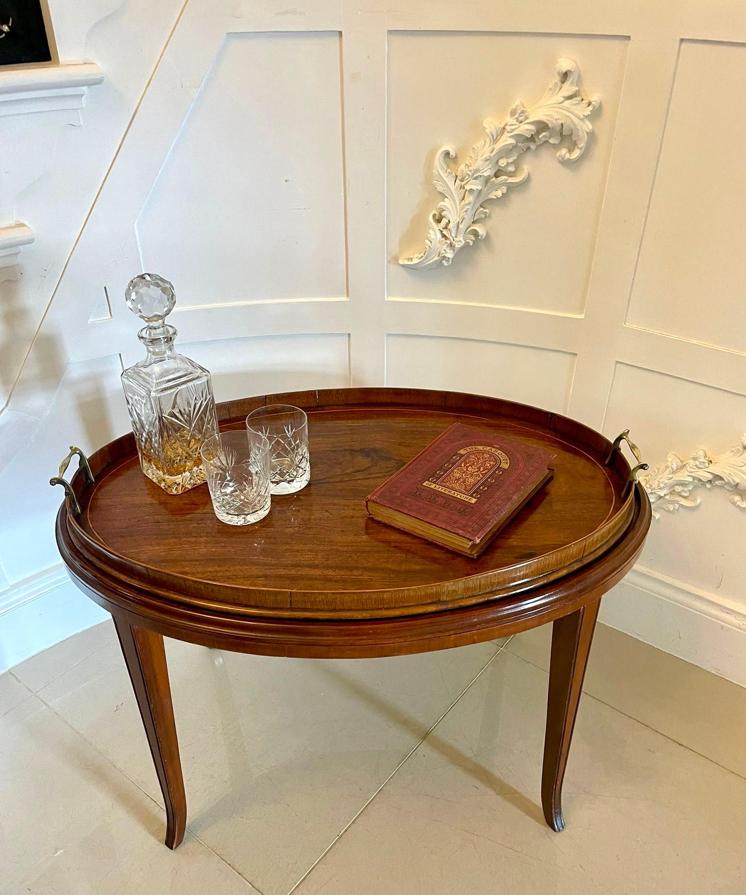 Large Antique Edwardian oval quality figured mahogany tea tray on stand having a removable quality figured mahogany oval tea tray with brass carrying handles and satinwood inlay on an oval mahogany stand with a moulded edge standing on four square