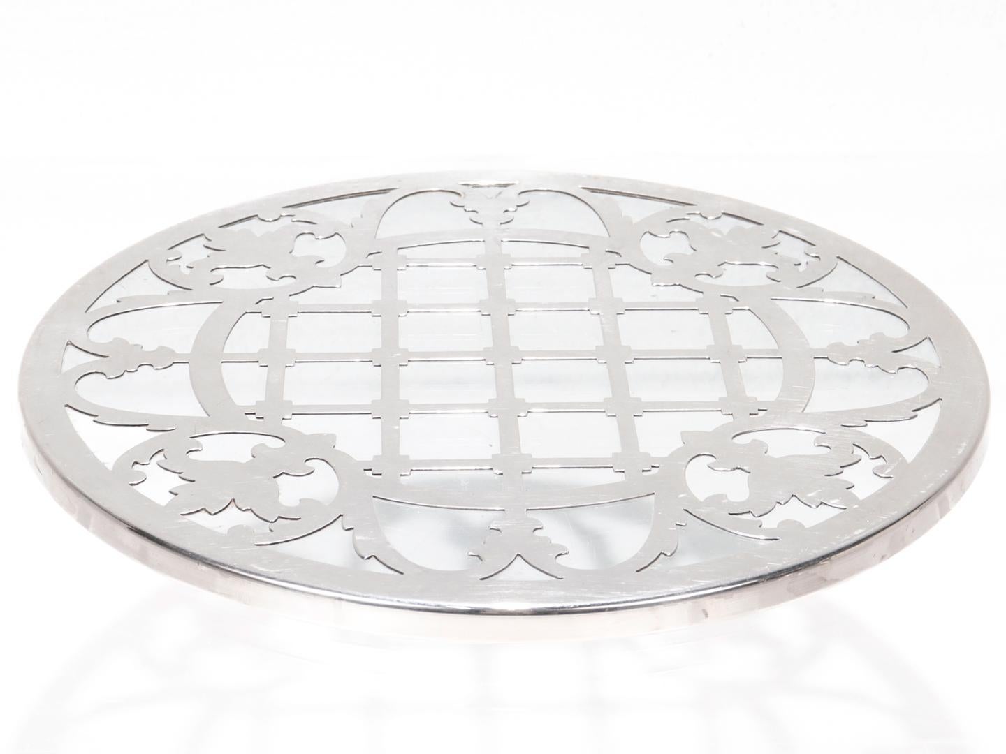 A fine antique wine trivet.

With a thick sterling silver overlay with a geometric motif on a glass base.  

Simply a wonderful trivet!

Date:
Early 20th Century

Overall Condition:
It is in overall good, as-pictured, used estate
