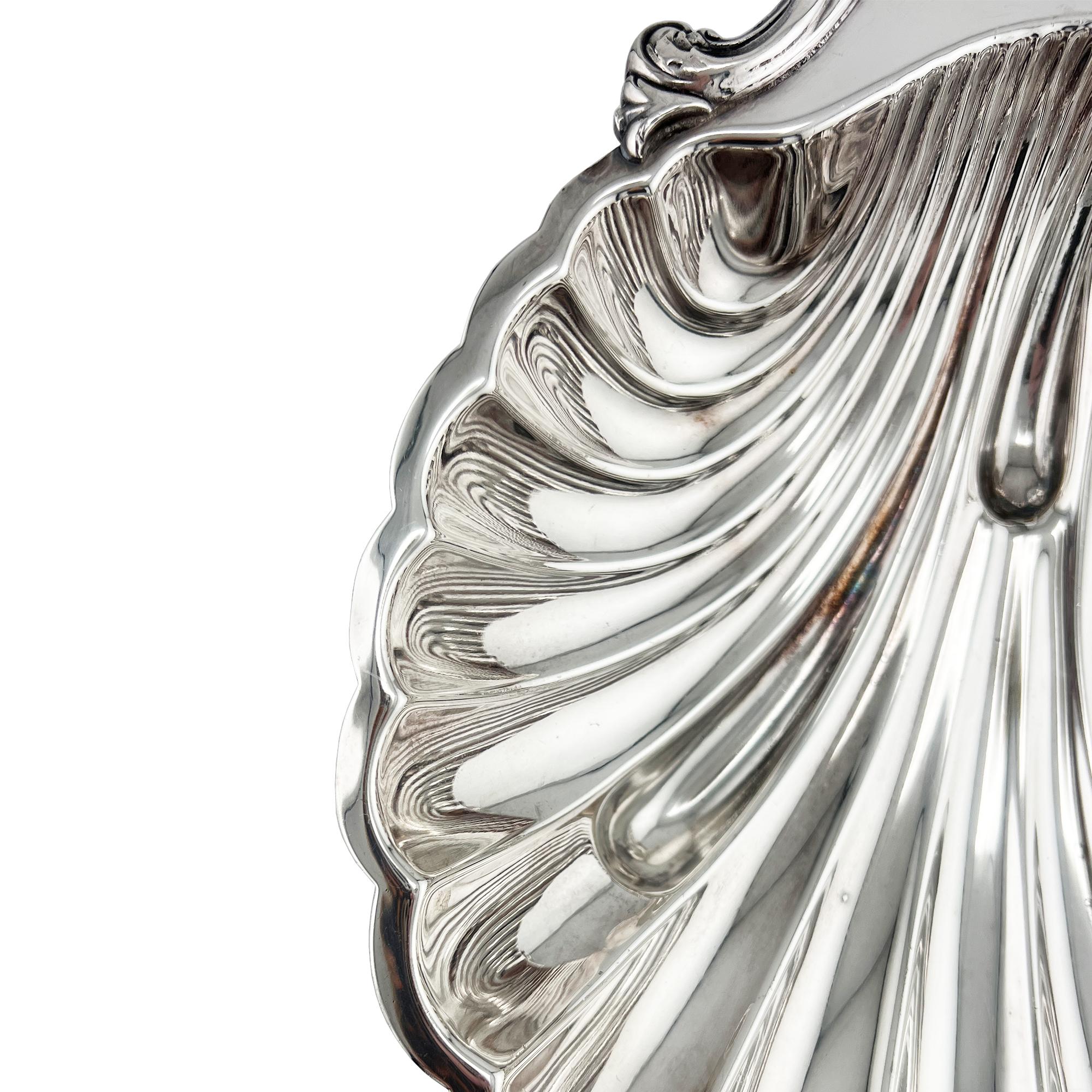 Exemple frappant de l'artisanat américain en argenterie, ce plat de service orné en forme de coquille a été créé par l'International Silver Company et porte la marque EGW&S (E.G. Webster & Sons), l'une des filiales historiques de l'entreprise. Avec