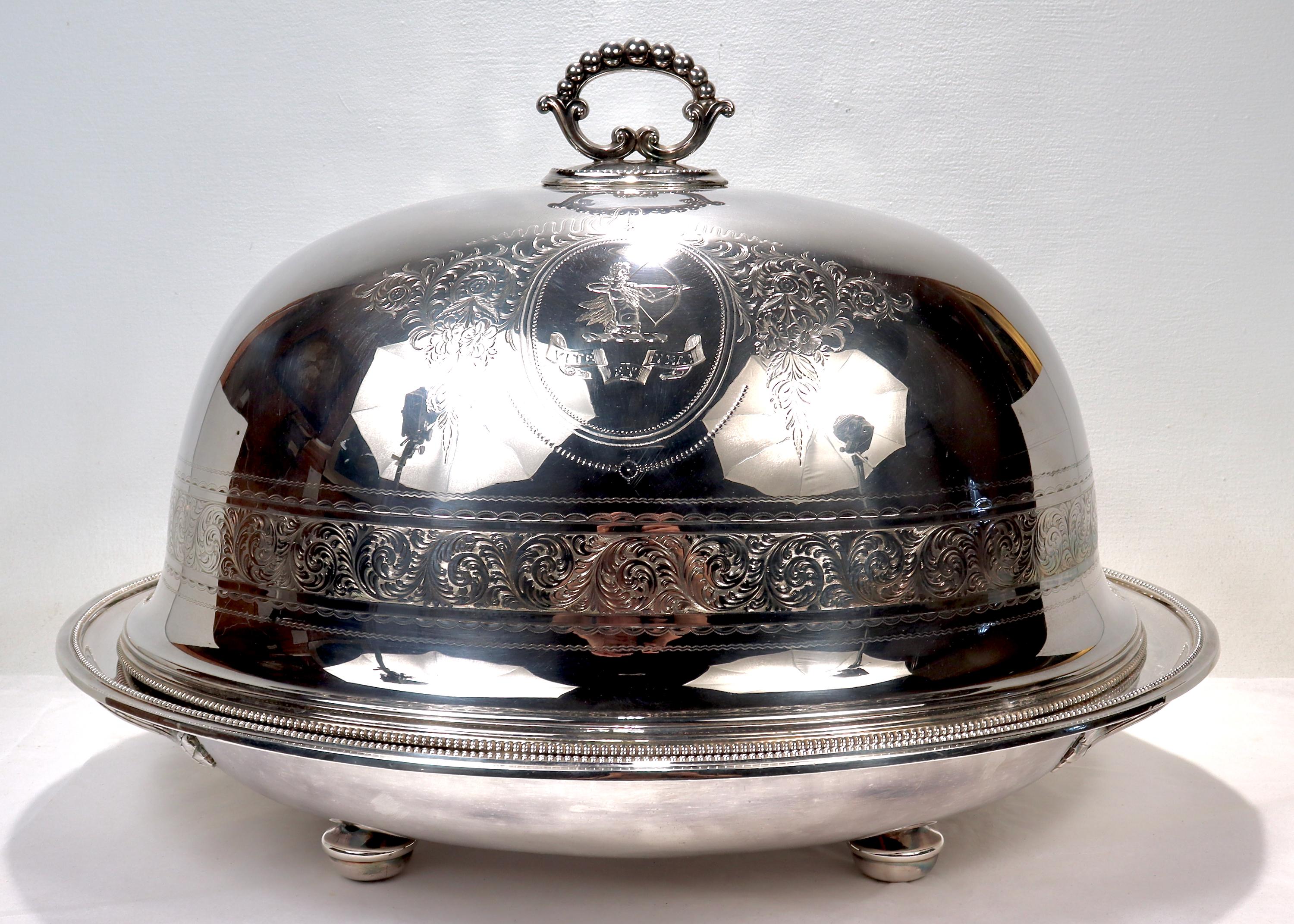 A very fine and large antique Armorial silver plate covered warming roast platter.

By Elkington & Co.

Comprising a large twin handled warming tray and a conforming dome. The hollow bodied tray has a side mounted screw top opening for filling with