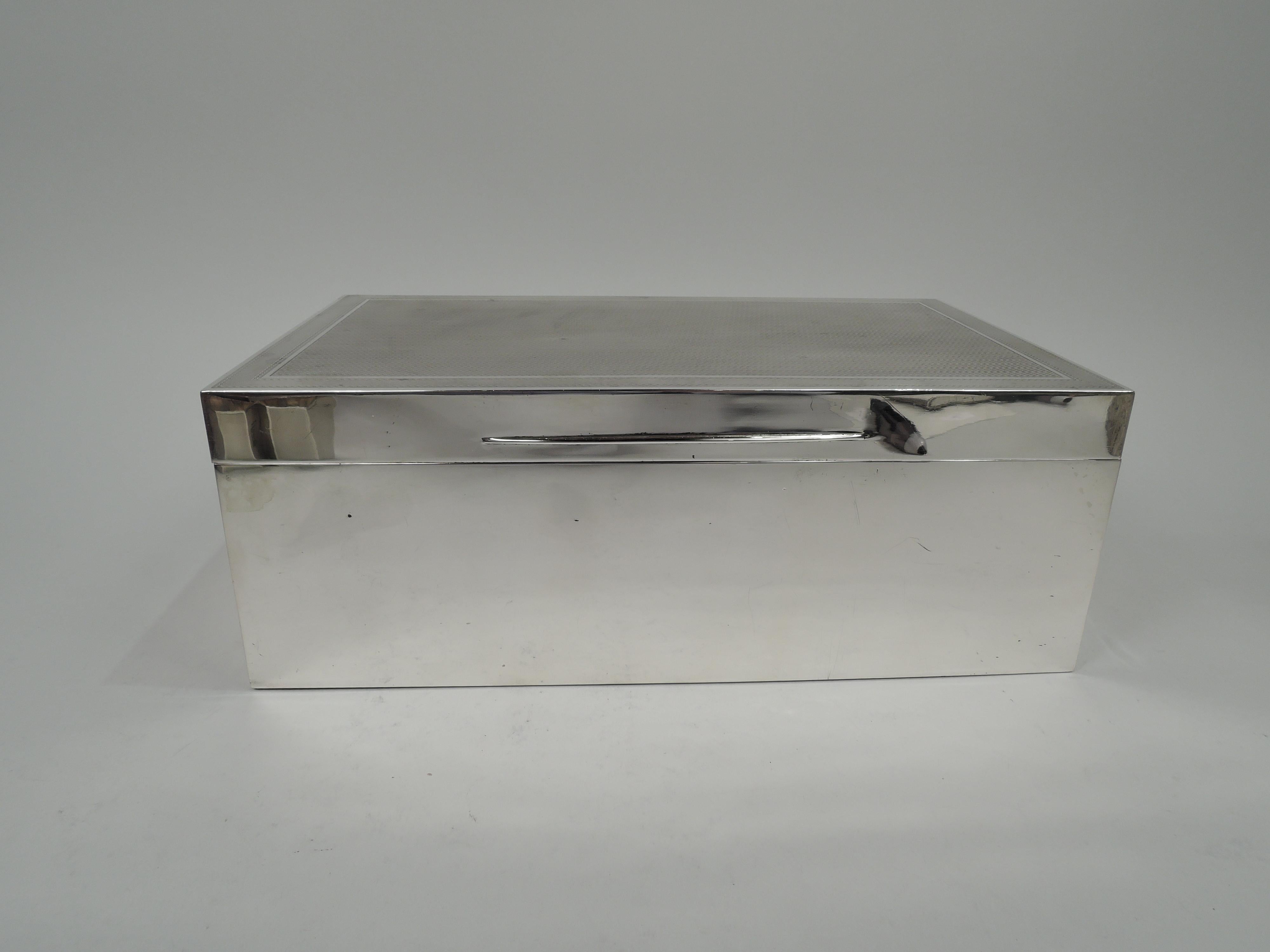 Caja de puros de plata de ley Jorge V. Fabricado por Barnard & Sons, Ltd en Londres en 1930. Rectangular con lados rectos. Tapa abisagrada y con lengüeta cónica; solapa superior con dibujo lineal torneado a máquina bordeado por líneas envolventes