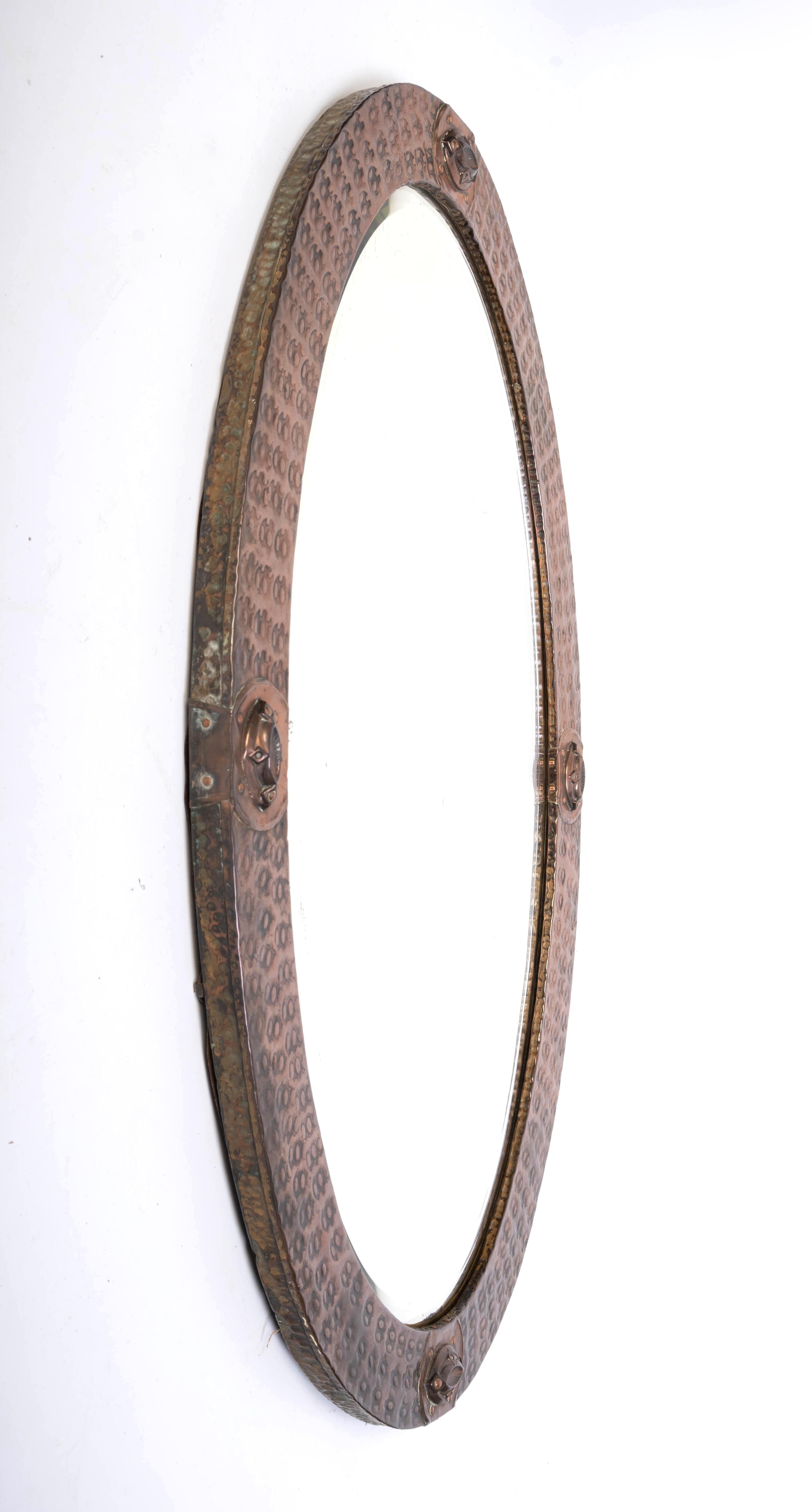 Antiguo espejo ovalado inglés Arts And Crafts de cobre martillado 
Liberty & Co. C.1910

En muy buen estado acorde con la edad. La placa de espejo original está algo oxidada.
