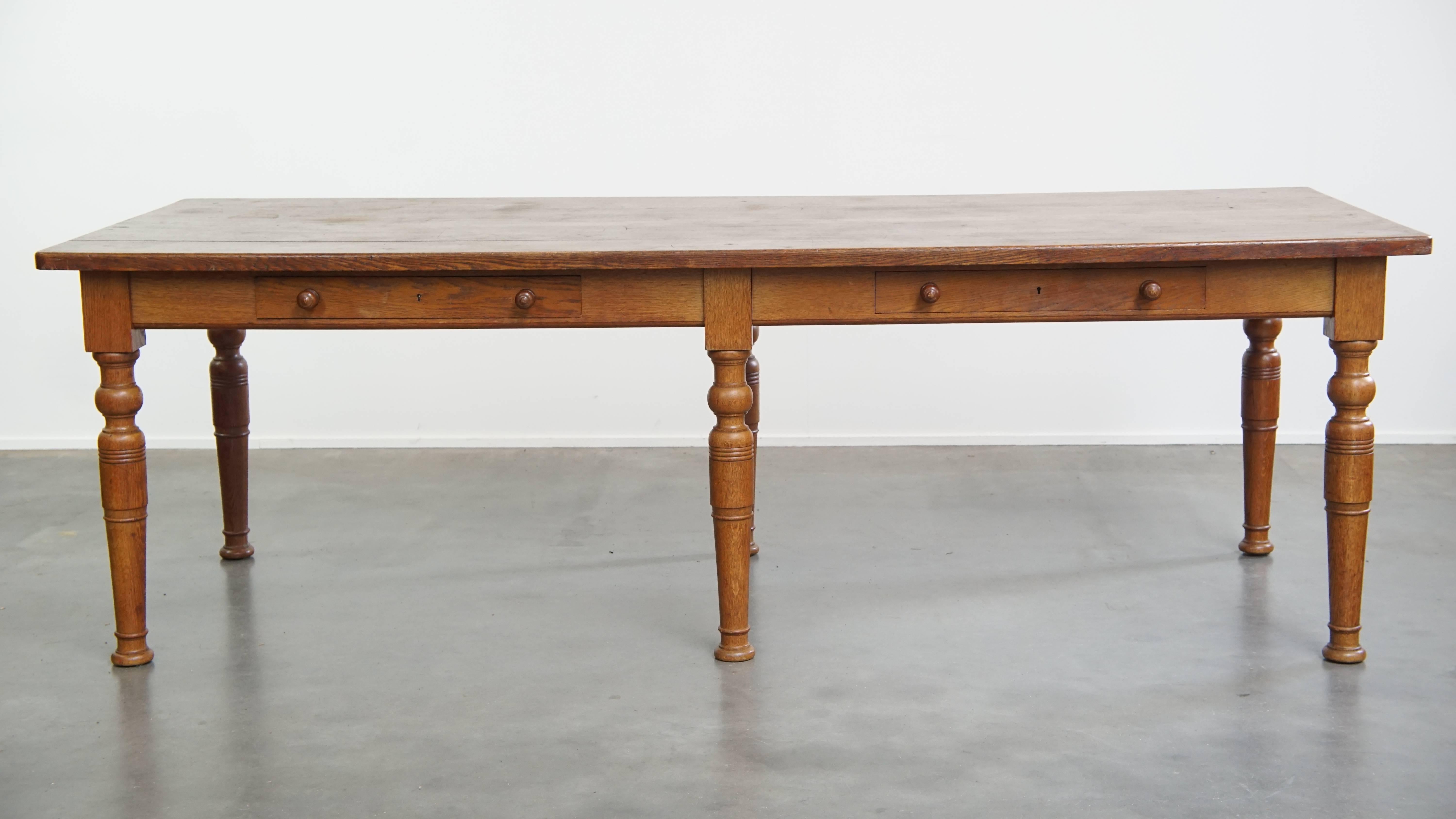 Offered here is this large, robust, and timeless antique English dining table made of solid oak.

This impressive antique table features a strong presence and has been beautifully crafted from solid oak. Over the years, it has developed a rich