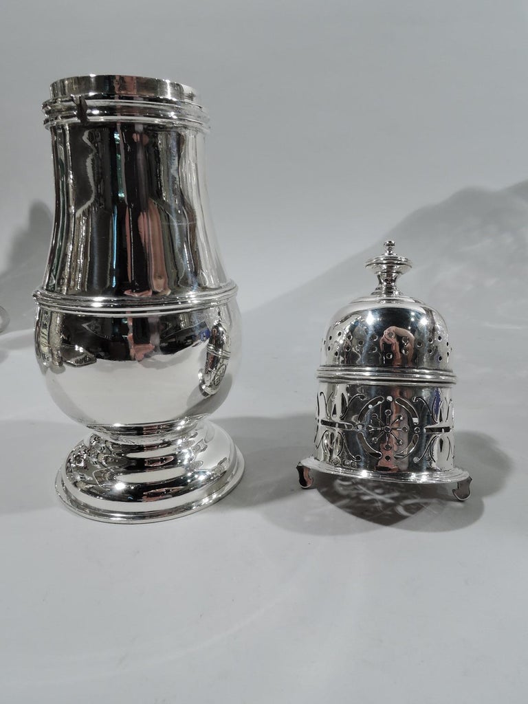 George V sterling silver sugar caster. Made by William Hutton & Sons, Ltd in Sheffield in 1911. Girdled baluster on domed foot. Cover has ornamental piercing and vasiform finial. Fully marked. Weight: 10.5 troy ounces.
