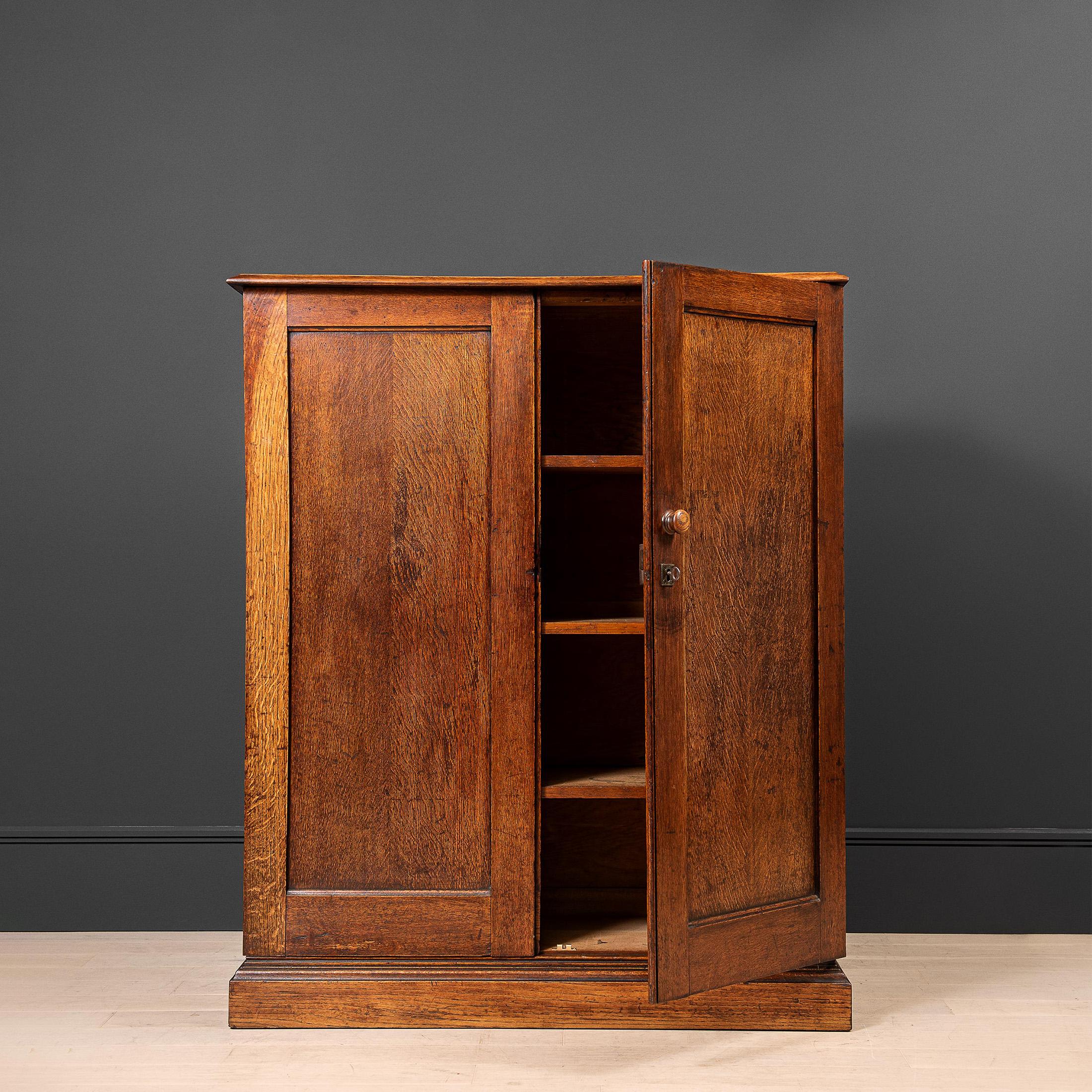 A large antique English oak cupboard/cabinet with internal shelves. Beautifully coloured patinated English oak construction with original brass fittings. From very early 20th century - 1910 - 1920. 
A very practical storage piece with a simple and