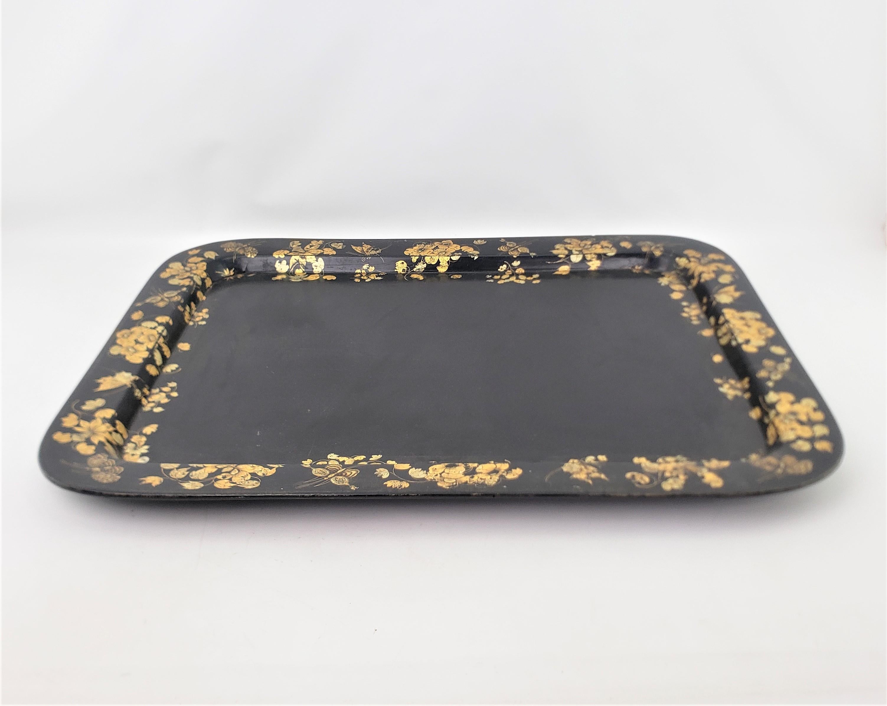 This extremely large antique serving tray is unsigned, but presumed to have originated from England and date to approximately 1880 and done in the period Late Victorian style. The tray is composed of paper mache with a polished black lacquer finish