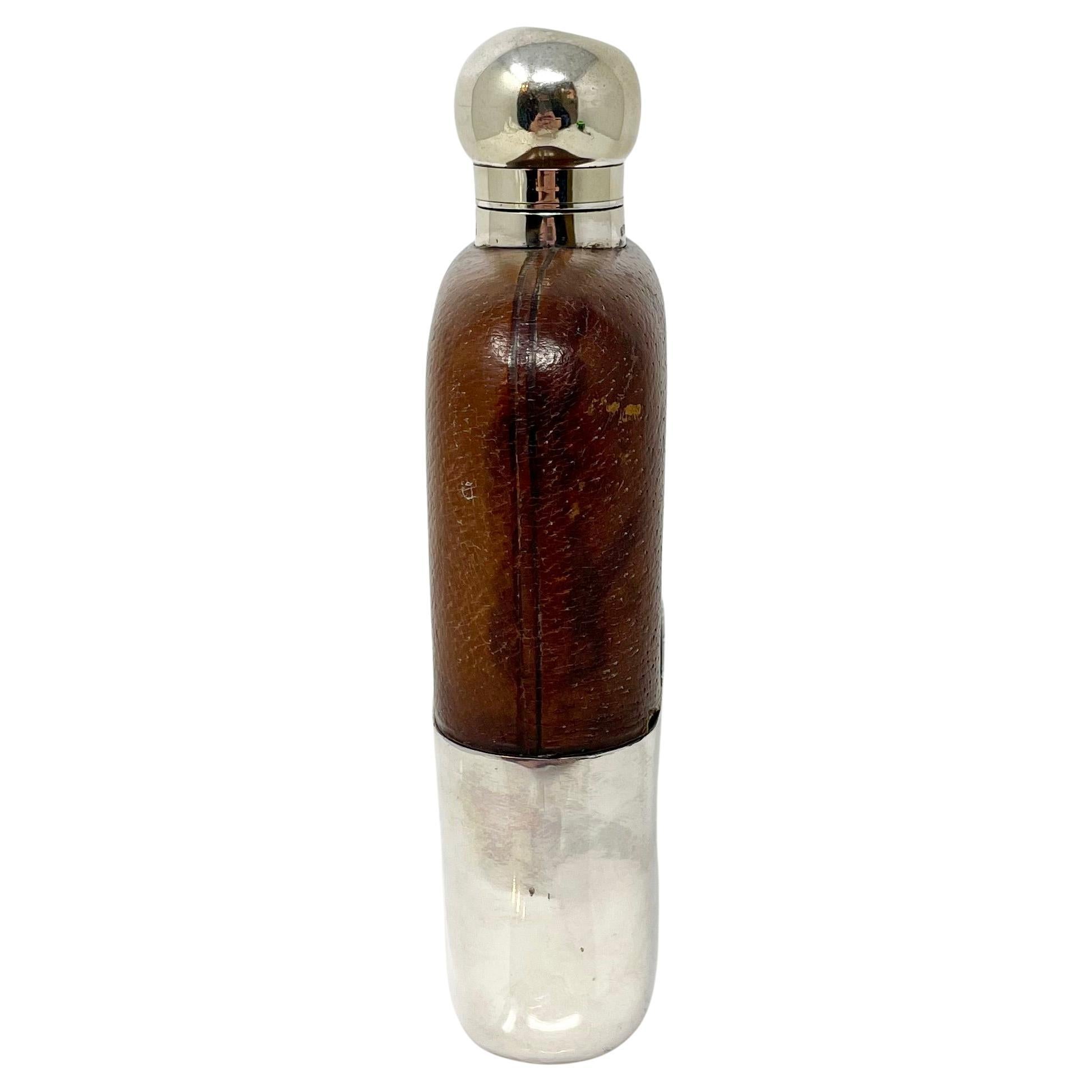 Grande gourde anglaise ancienne en métal argenté, cuir et verre, vers 1900.
Avec gobelet amovible. 